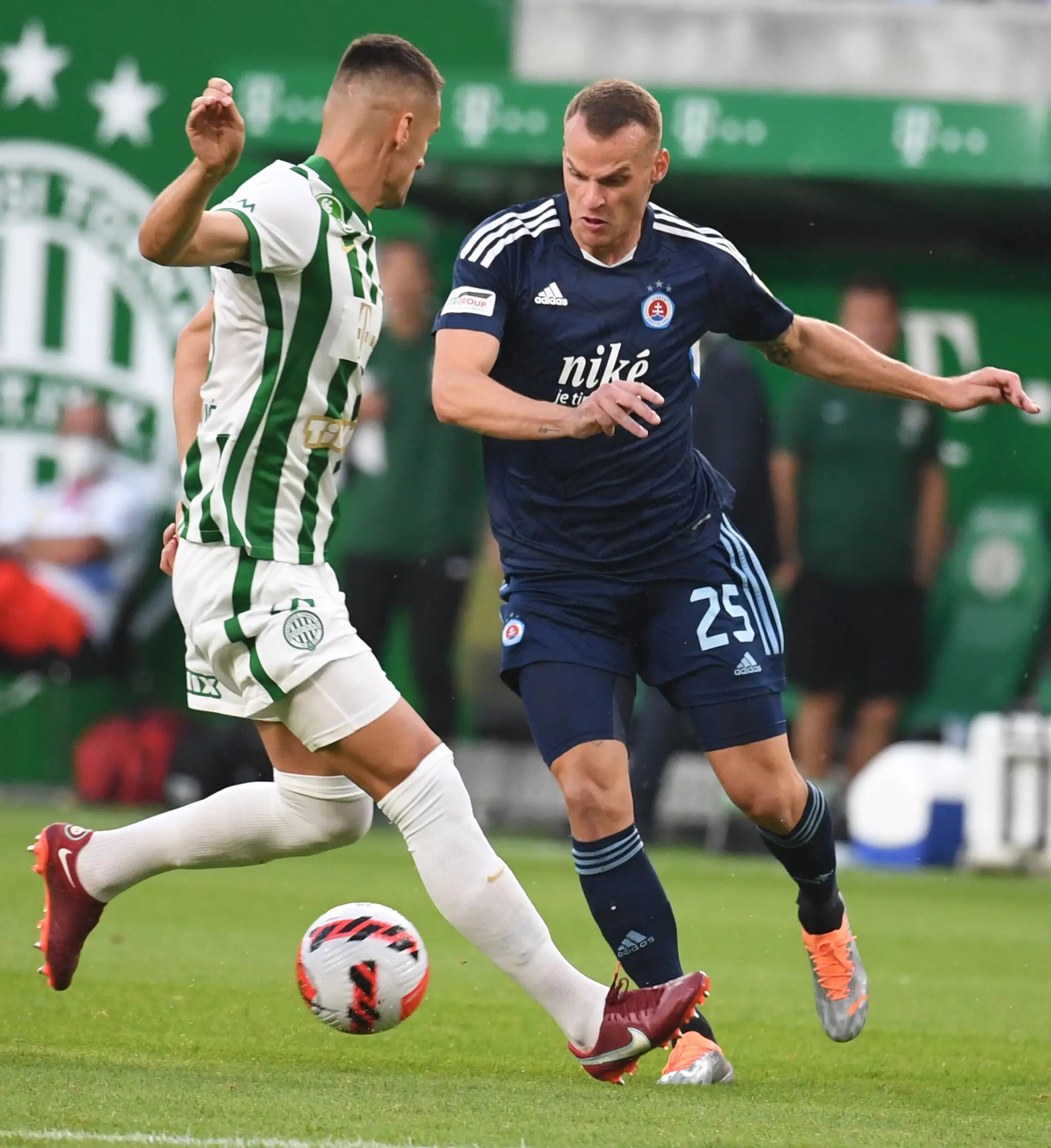 Futbalista Slovana Lukáš Pauschek (vpravo) a hráč Ferencvárosu Budapešť Adnan Kovačevič bojujú o loptu počas úvodného zápasu 2. predkola LM.