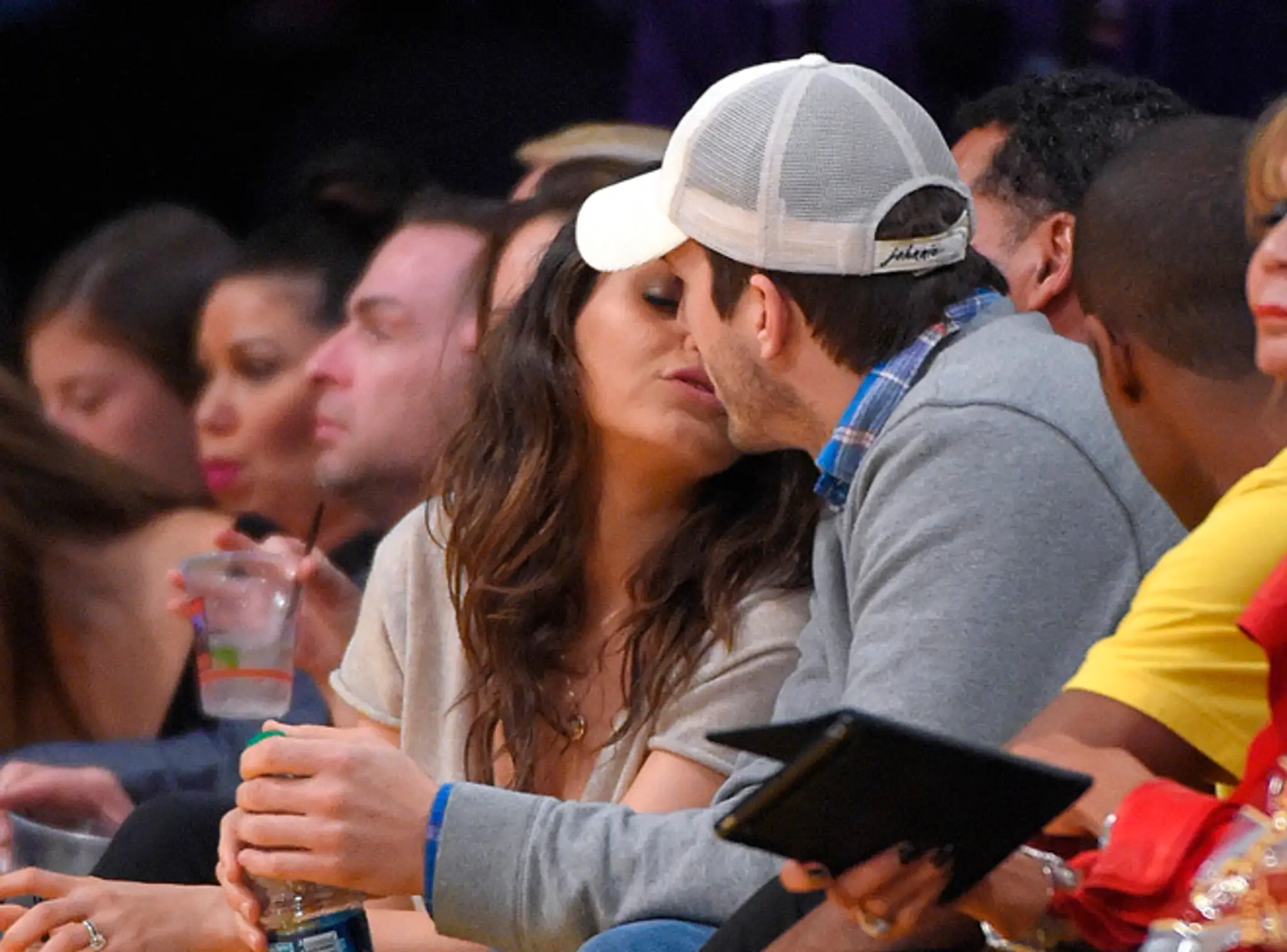 Bozkávajúca sa Mila Kunisová a Ashton Kutcher na zápase NBA.
