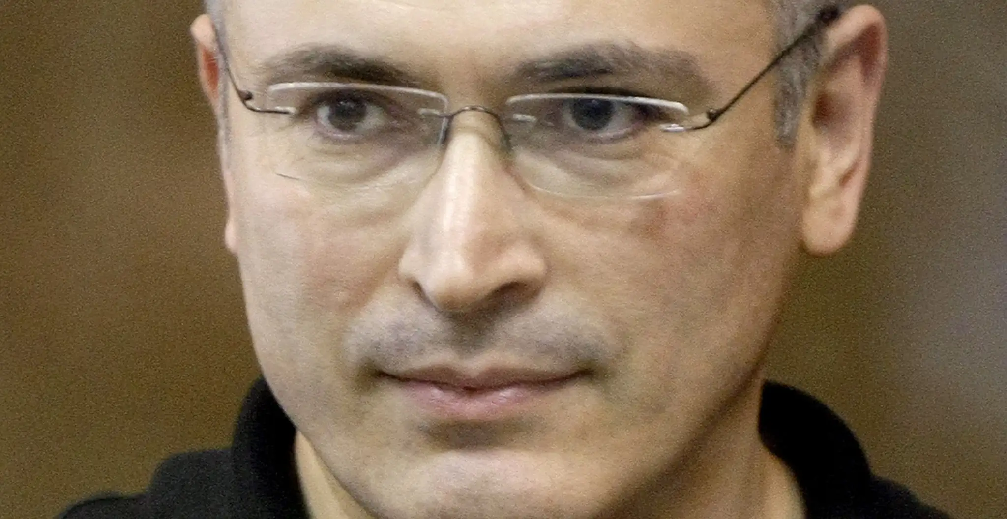 Bývalý šéf Jukosu Michail Chodorkovskij stojí za sklenenou stenou v súdnej sieni v Moskve. (archív 2011)