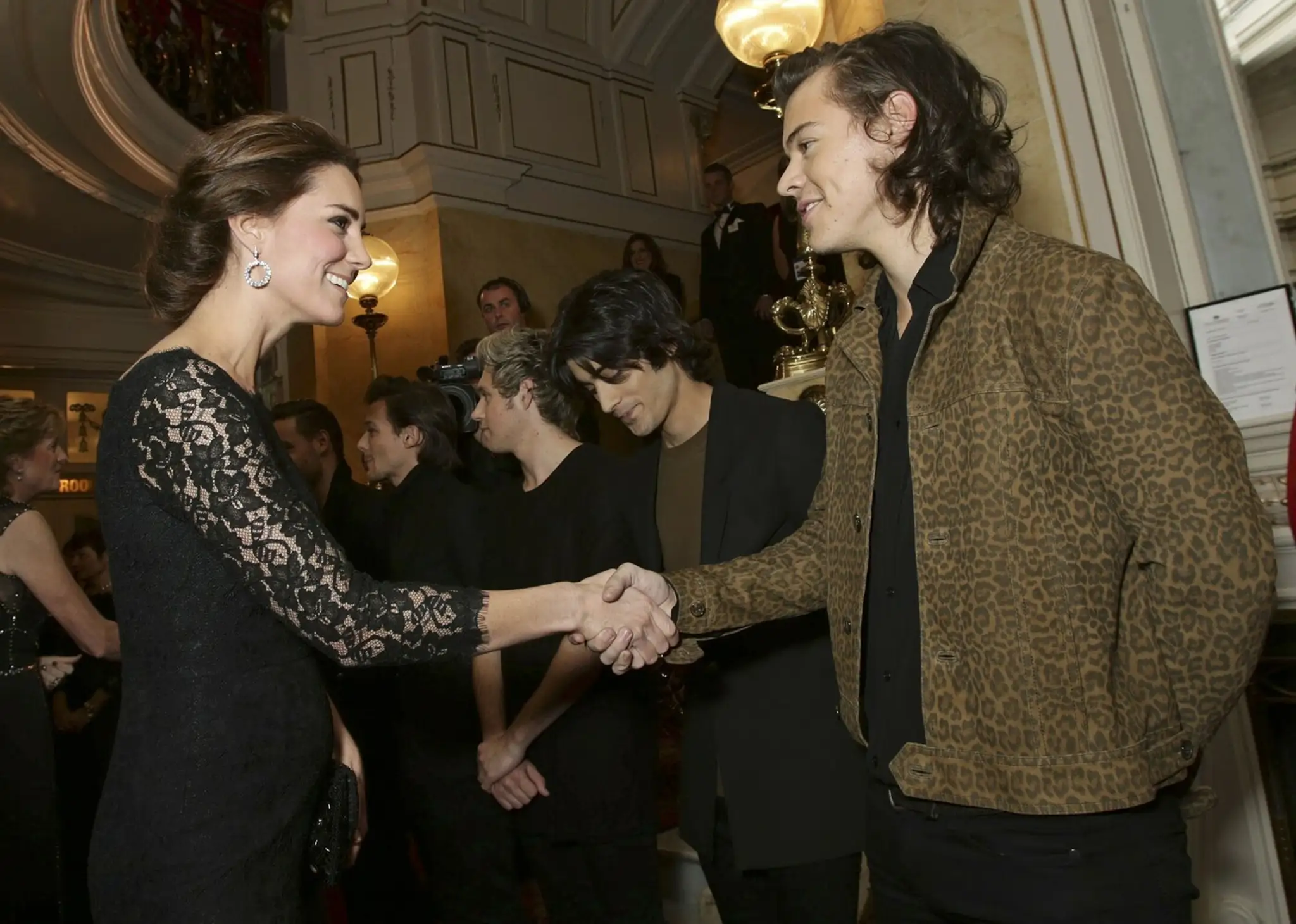 Kate Middleton podáva ruku Harrymu Stylesovi z One Direction.