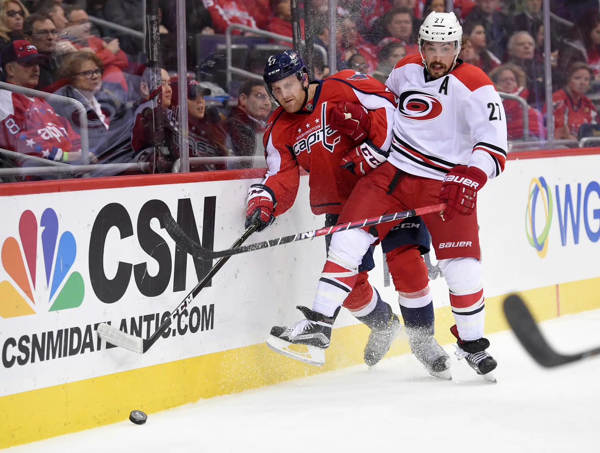 Bek Caroliny Justin Faulk (vpravo) proti Karlovi Alznerovi z Washingtonu Capitals.