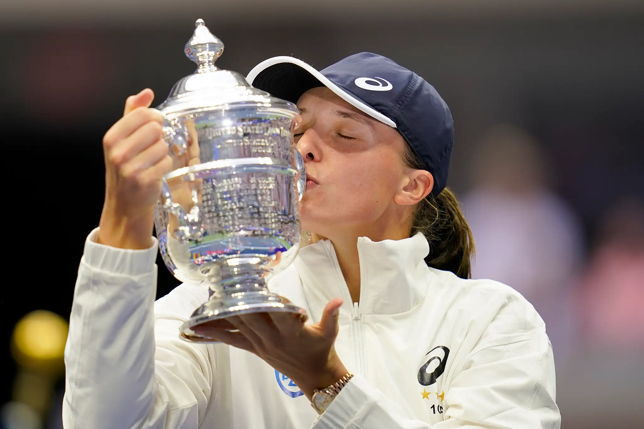 Poľská tenistka Iga Swiateková bozkáva trofej pre víťazku US Open po výhre  nad Tunisankou Ons Jabeurovou 6:2, 7:6.
