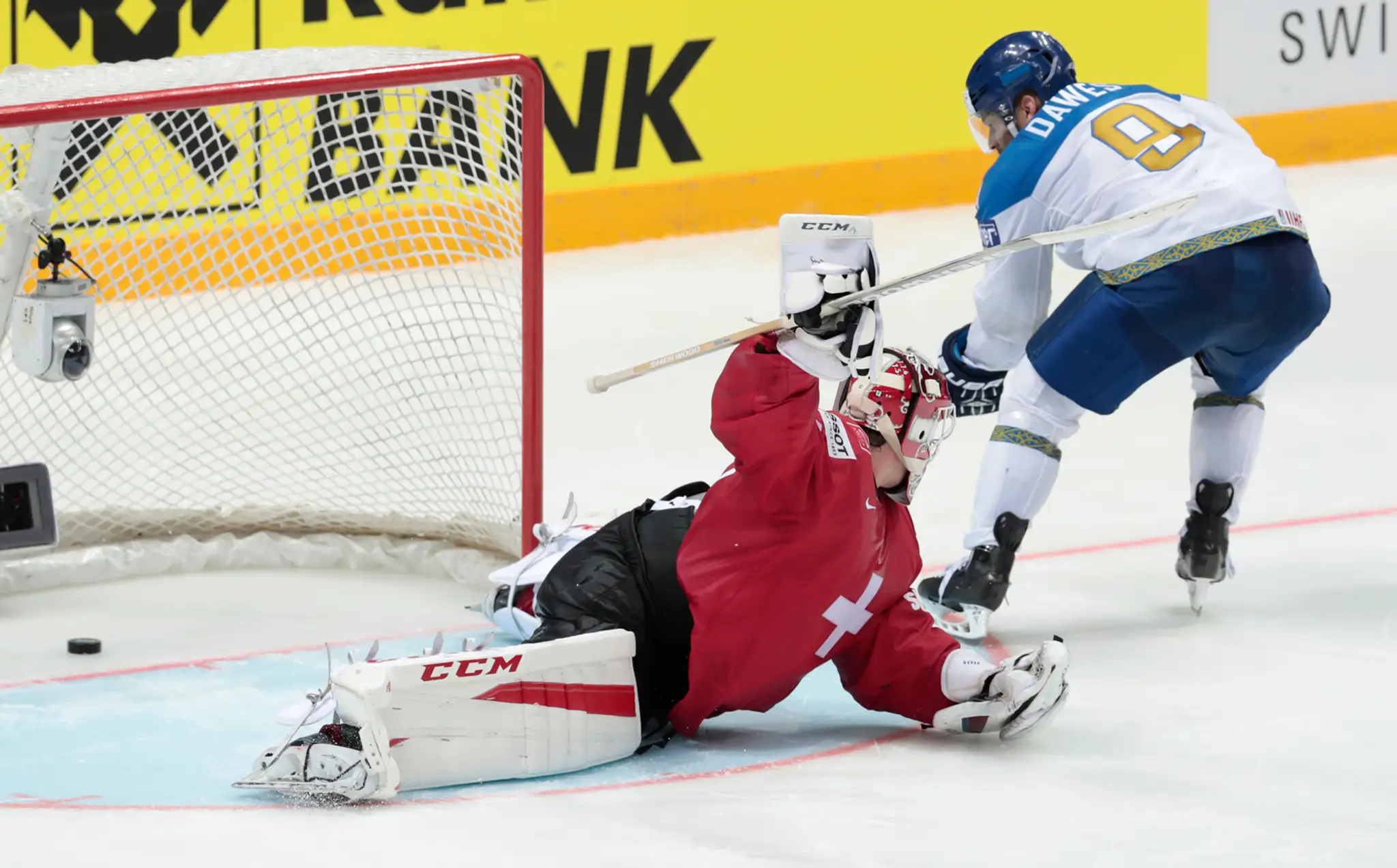 Kazach Nigel Dawes strieľa gól švajčirskemu gólmanovi Retovi Berrovi počas duelu na MS v Rusku.
