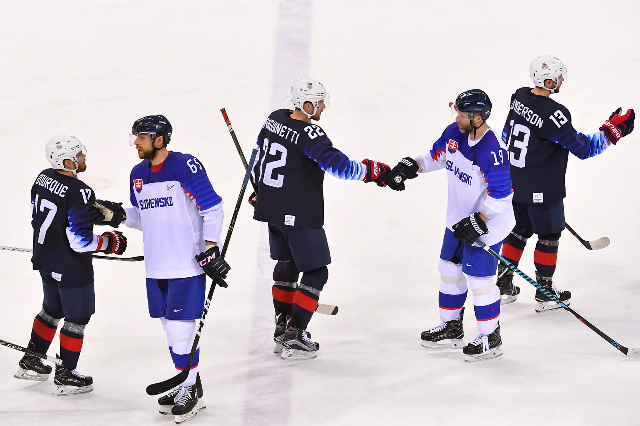 Americkí a slovenskí hokejisti (v bielom) si podávajú ruky po osemfinále ZOH 2018.