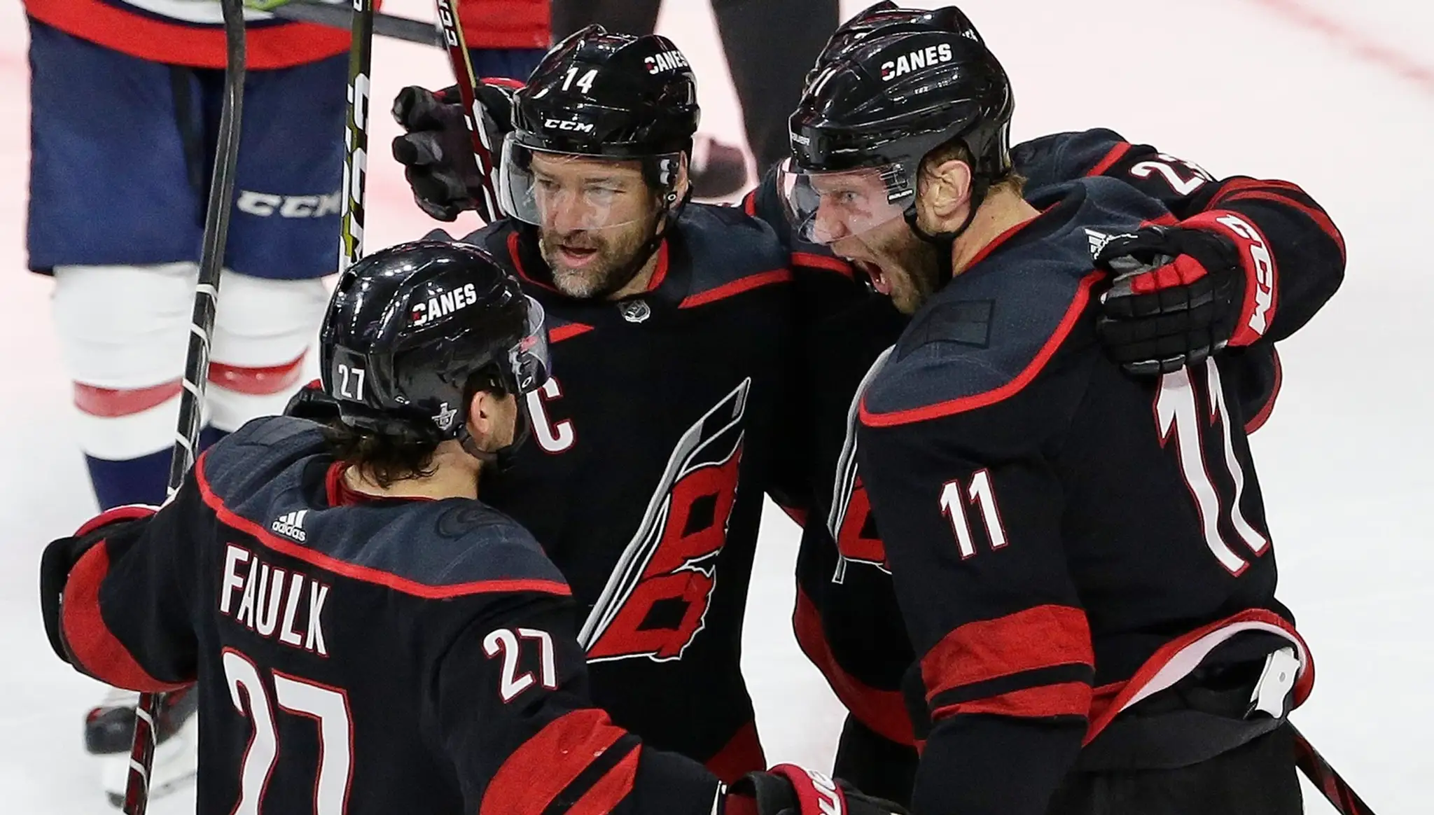 Hokejisti Caroliny Jordan Staal (11), Justin Faulk (27) a Justin Williams (14) sa tešia po strelení gólu.