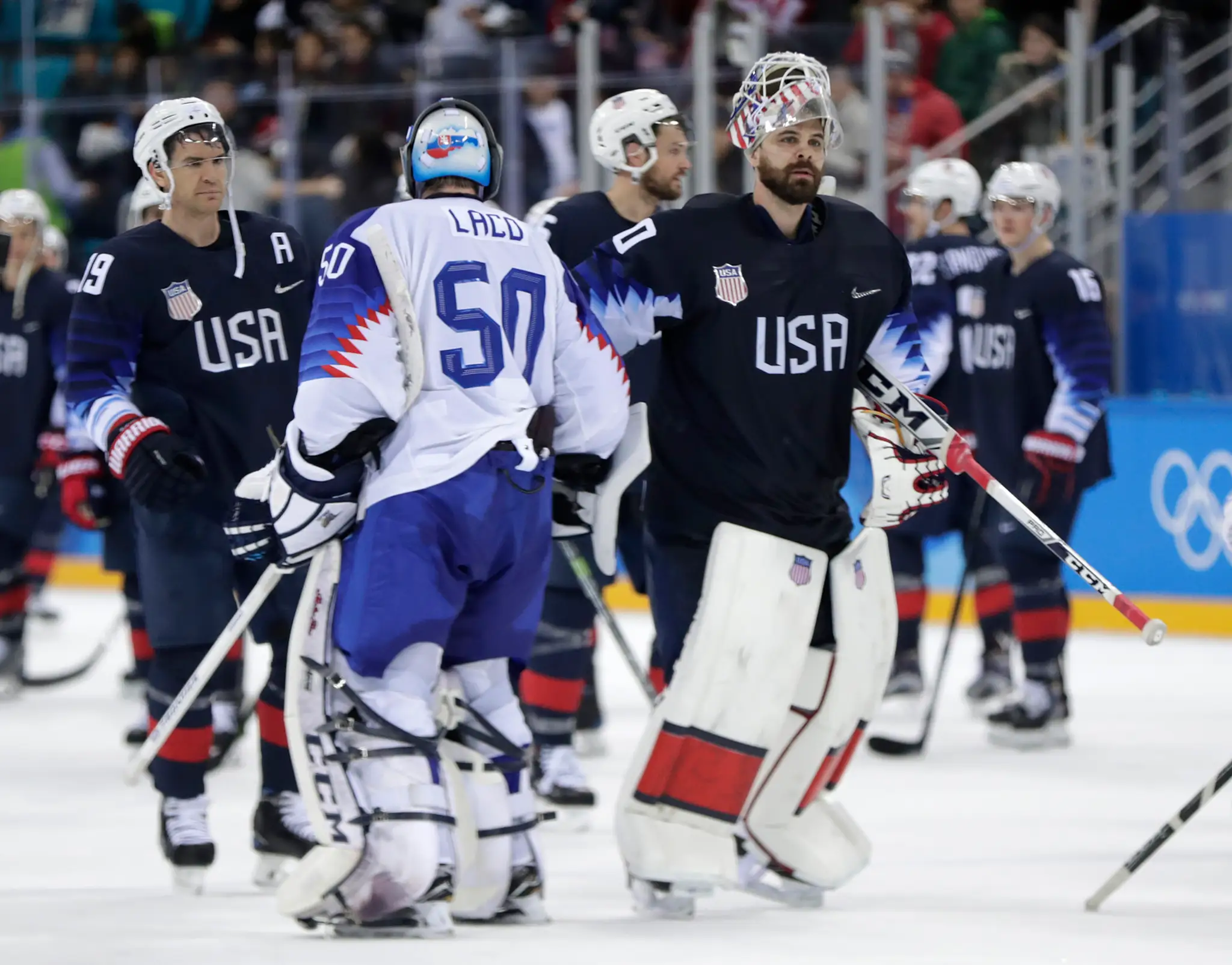 Gólman USA Ryan Zapolski (vpravo) si podáva ruku s konkurentom Jánom Lacom po osemfinále ZOH 2018.