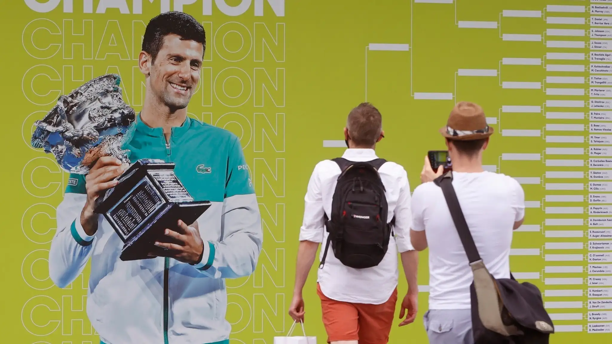 Fanúšikovia si fotia plagát s fotografiou srsbkého tenistu Novaka Djokoviča pred zápasmi 1. kola Australian Open.