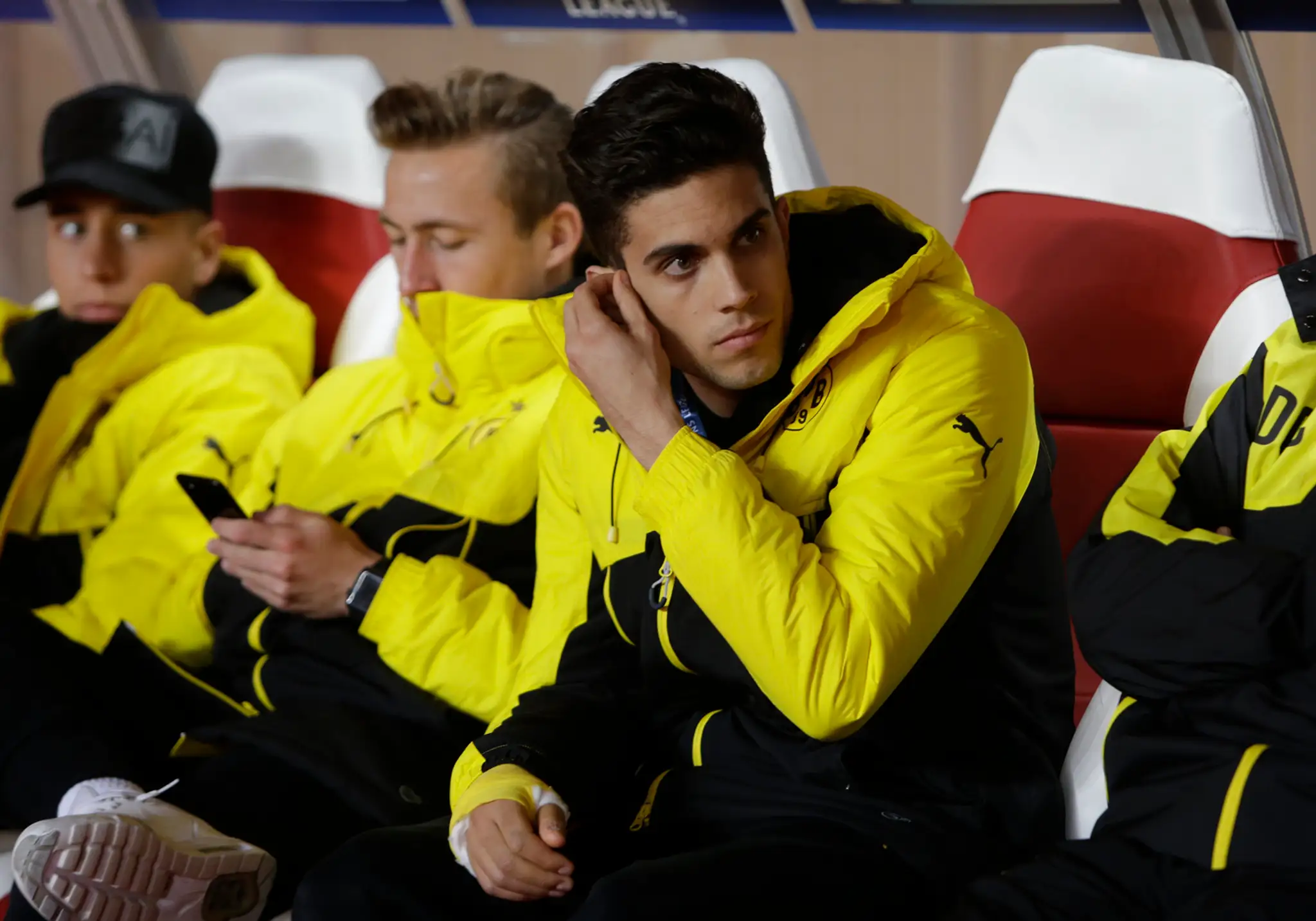 Obranca Borussie Marc Bartra (v popredí) sedí na lavičke pred odvetou štvrťfinále LM proti Monacu.