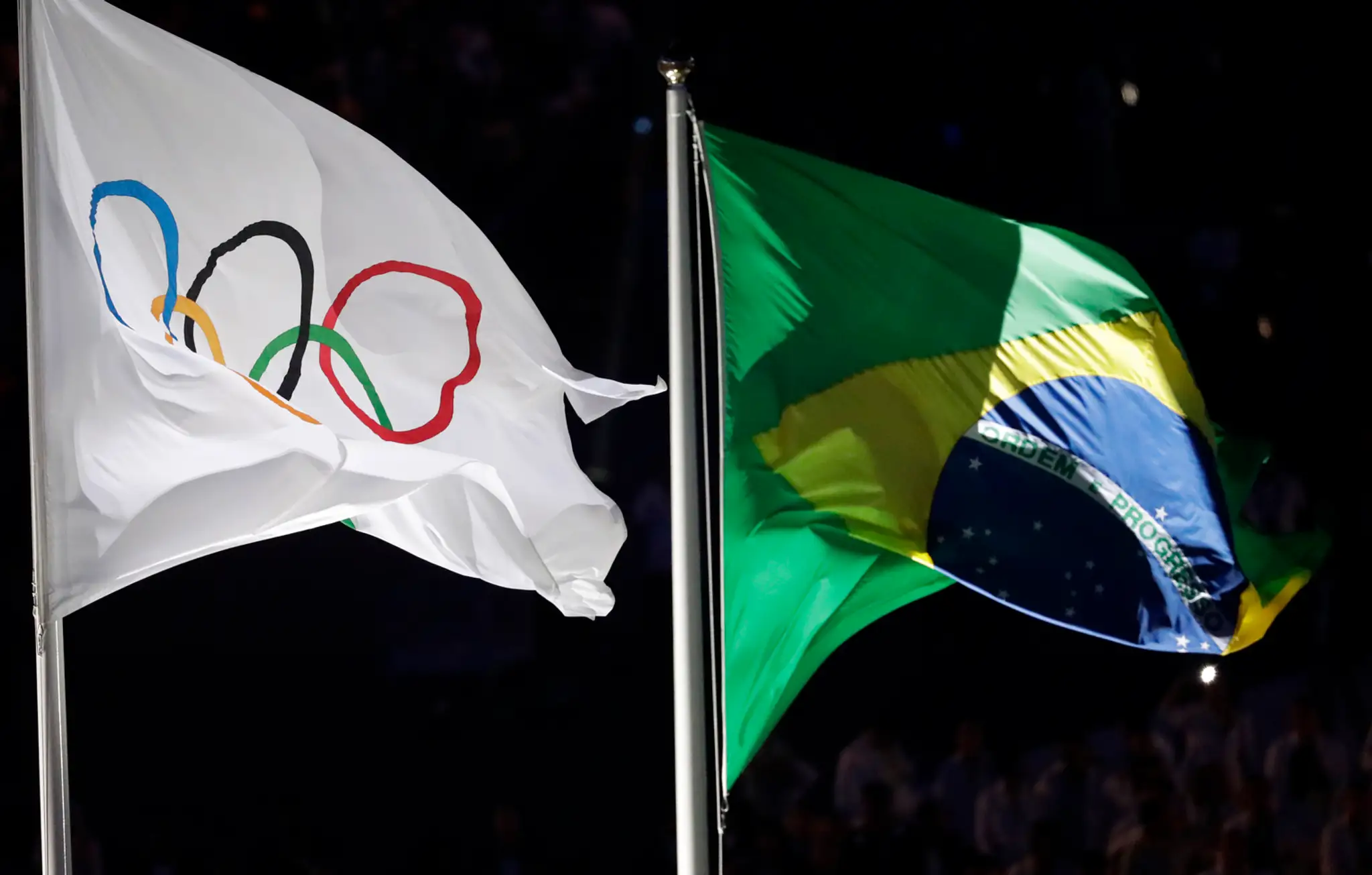 Vlajky Medzinárodného olympijského výboru (vľavo) a Brazílie visiace na štadióne Maracana počas otváracieho ceremoniálu OH v Riu