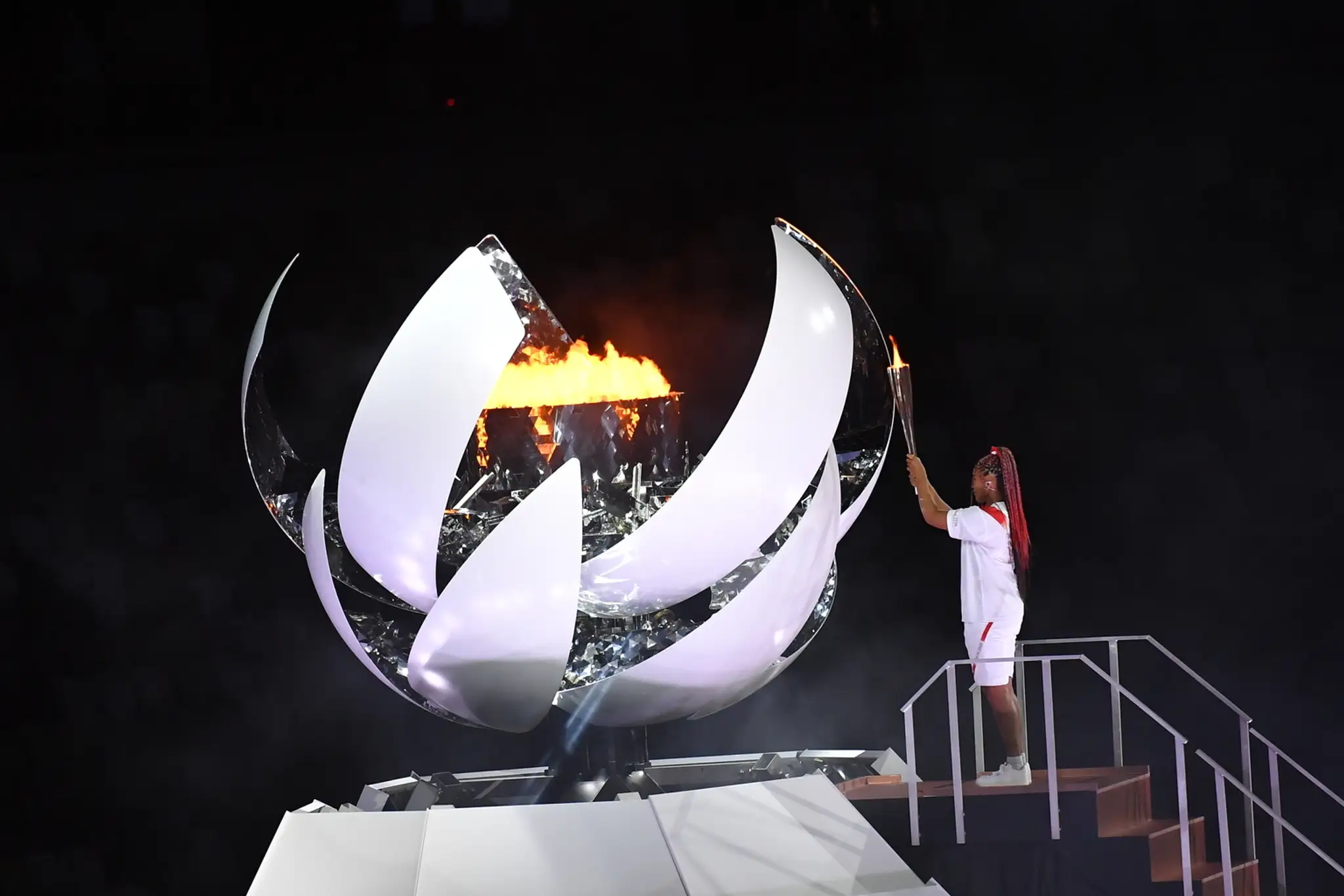 Na snímke japonská tenistka Naomi Osaková zapaľuje olympijský oheň počas otváracieho ceremoniálu na XXXII. LOH v Tokiu.