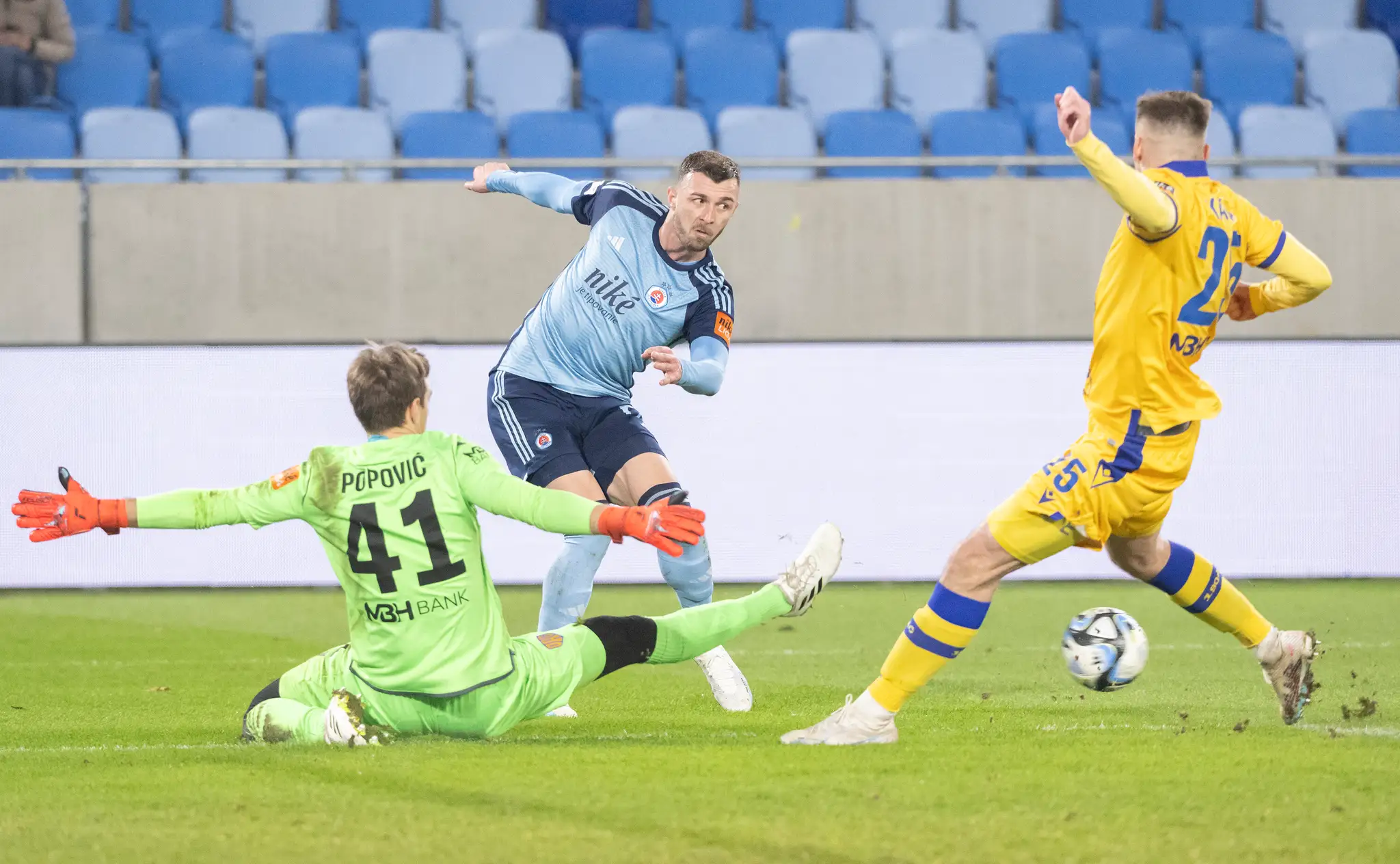 Uprostred Aleksandar Čavrič (Slovan), vľavo brankár Aleksandar Popovič a vpravo Filip Kaša (obaja DAC) v 18. kole Niké ligy.