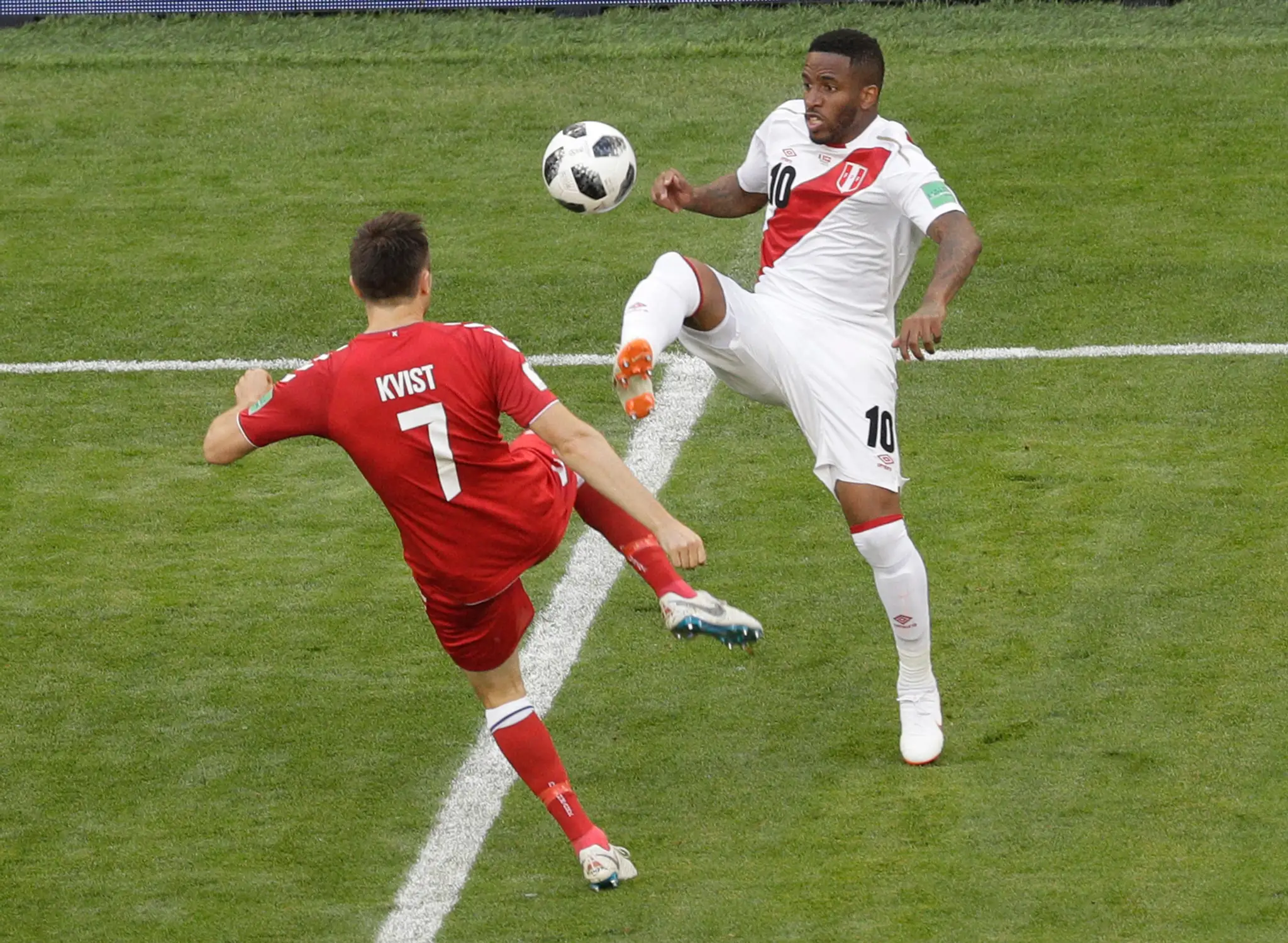 Dánsky futbalista William Kvist (vľavo) a hráč Peru Jefferson Farfan bojujú o loptu.