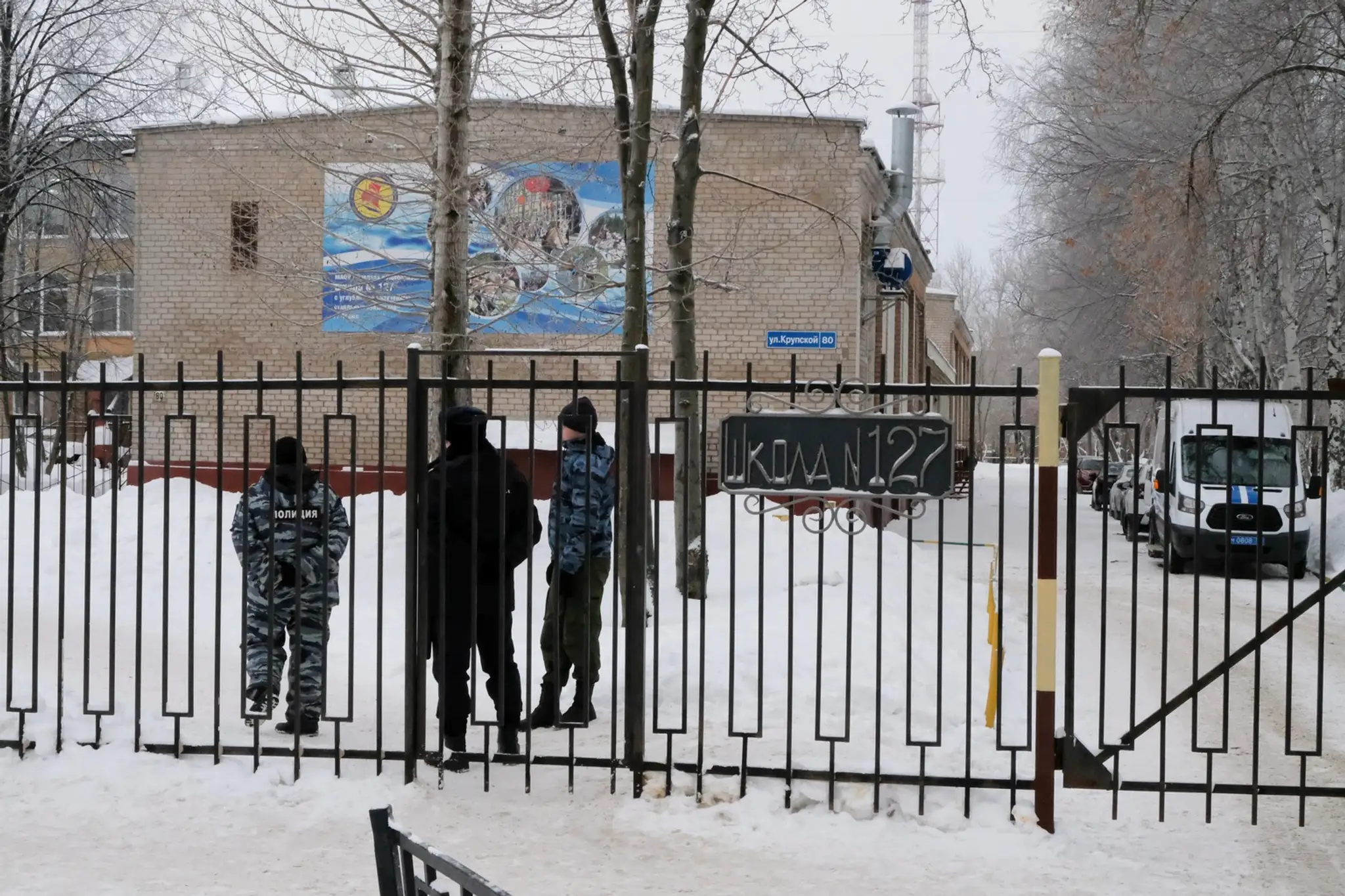Ruskí policajti hliadkujú pri vchode do strednej školy v ruskom meste Perm.