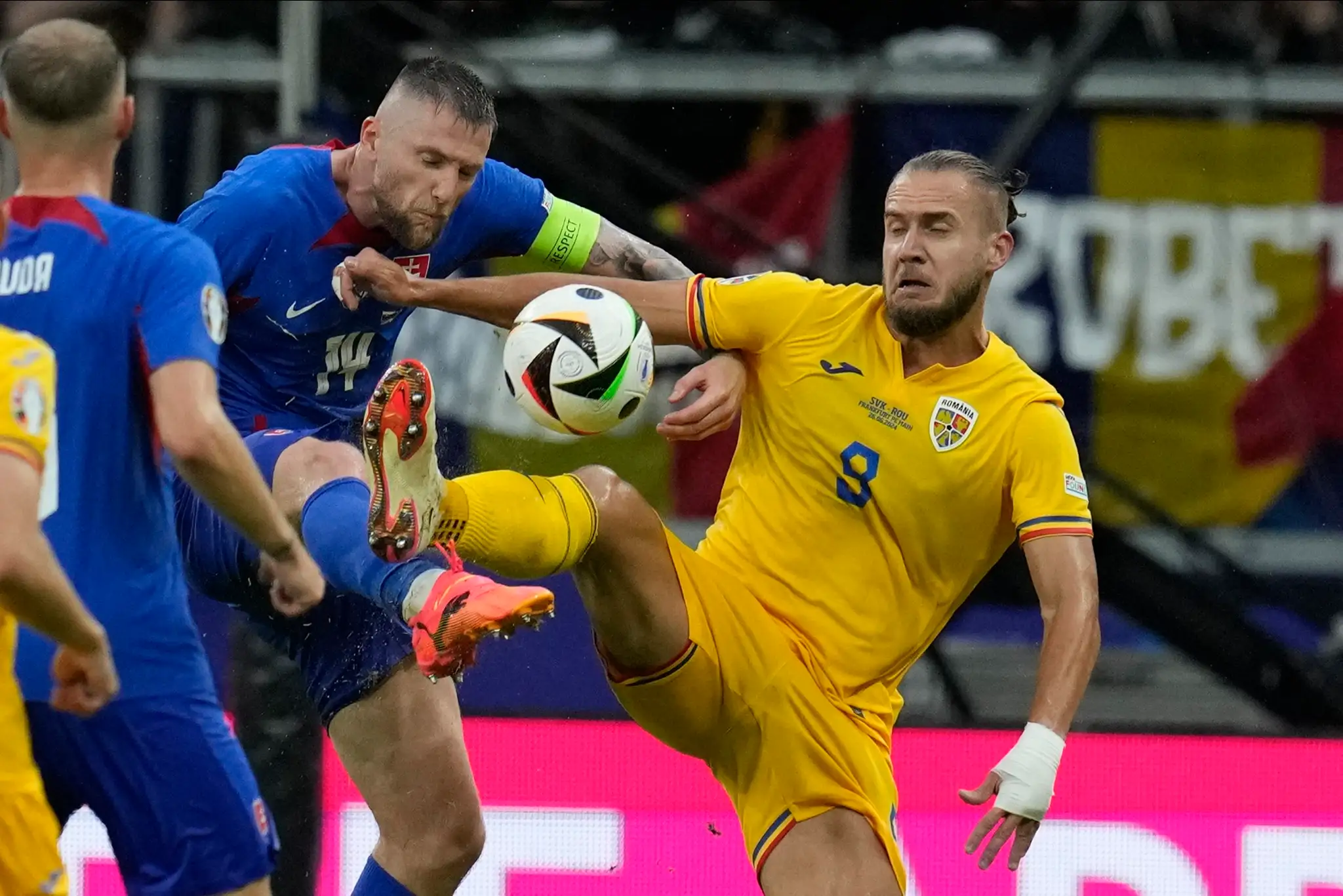Zľava Milan Škriniar a Rumun George Puscas v súboji v zápase na ME 2024.