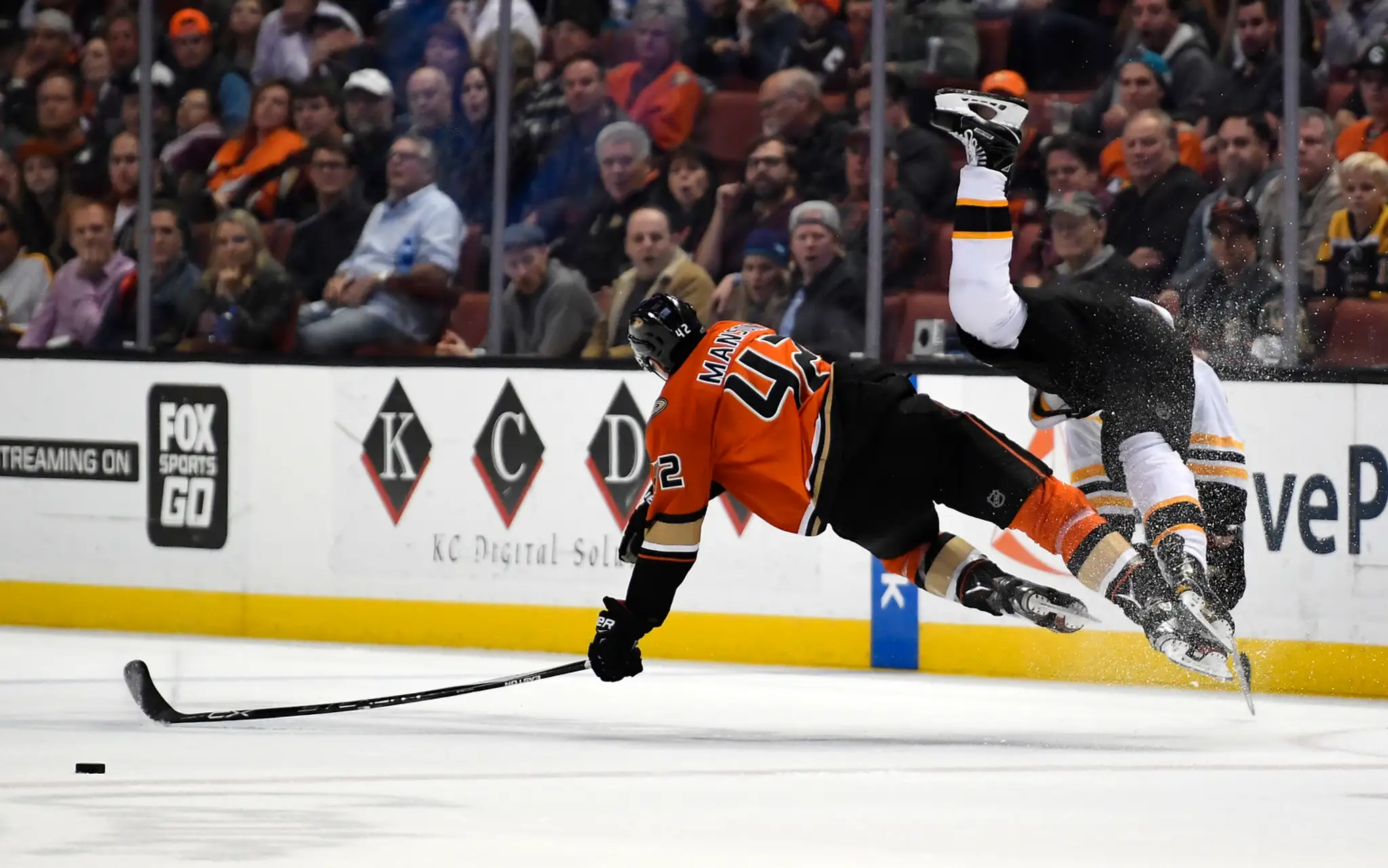 Obranca Anaheimu Ducks Josh Manson po zrážke s Bradom Marchandom z Bostonu Bruins.