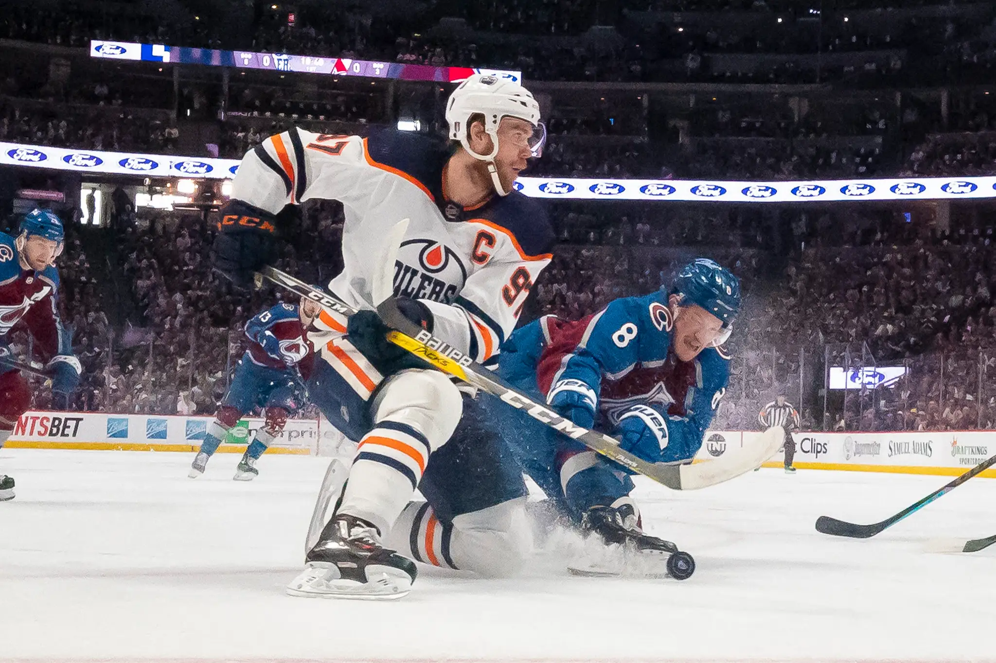 Connor McDavid (Edmonton) v súboji s Caleom Makarom (Colorado). 