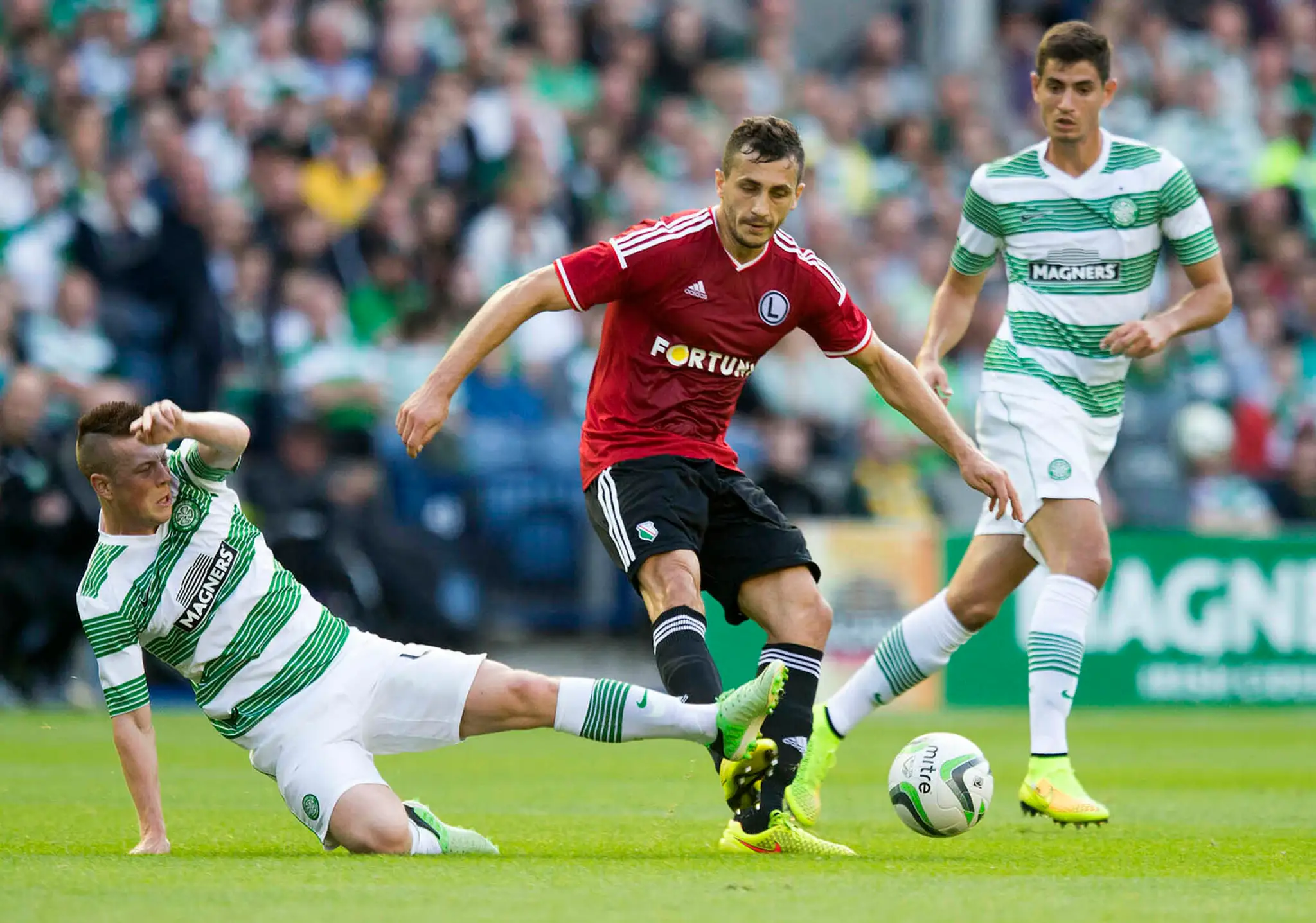Tomasz Jodlowiec (uprostred) z Legie Varšava a Callum McGregor (vľavo) zo Celticu Glasgow v súboji o loptu v odvete 3. predkola