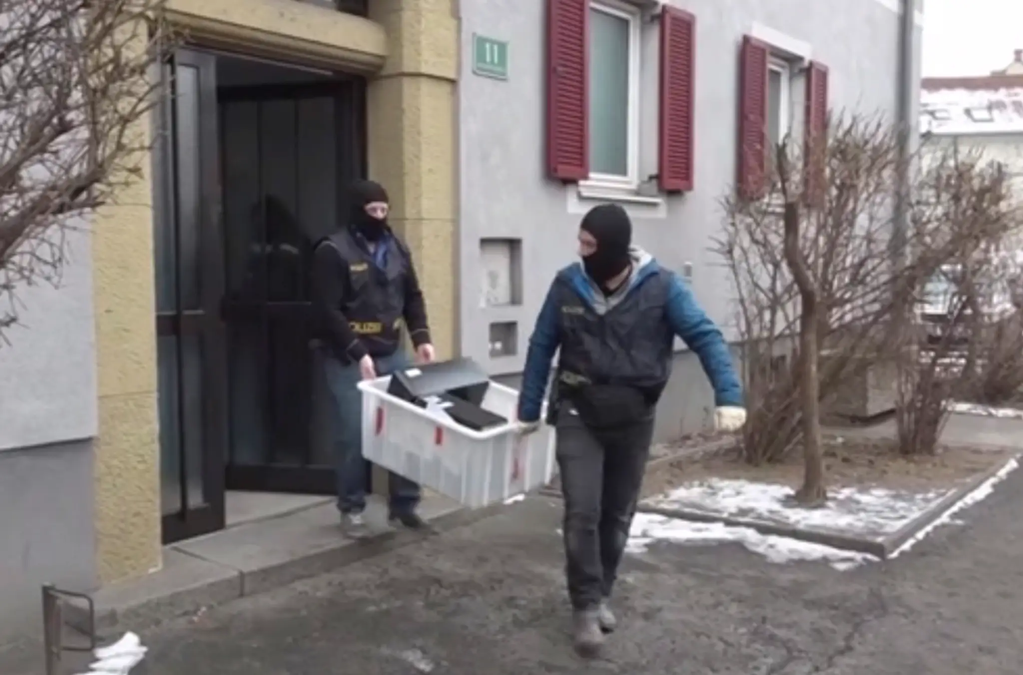 Rakúski policajti vynášajú počítače z domu v Grazi.