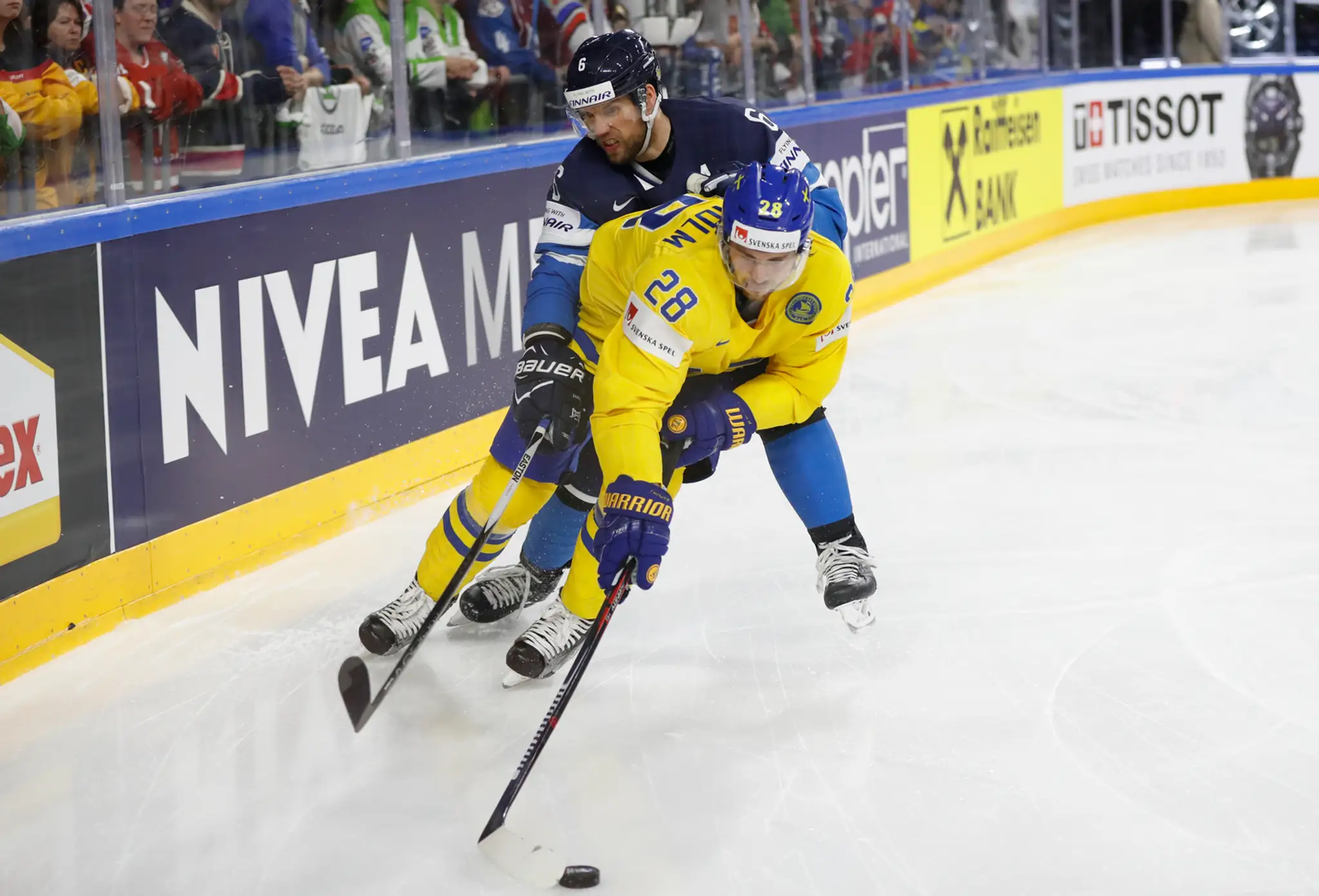 Elias Lindholm (vpravo) zo Švédska a Fín Topi Jaakola bojujú o puk v semifinále MS 2017. 