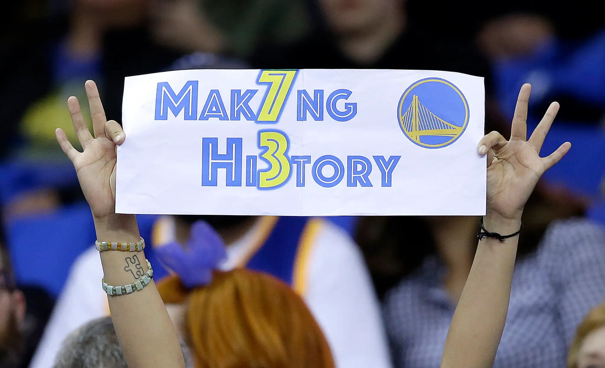Fanúšička Golden State Warriors drží transparent počas posledného zápasu základnej časti NBA v ktorom Warriors vytvorili nový re