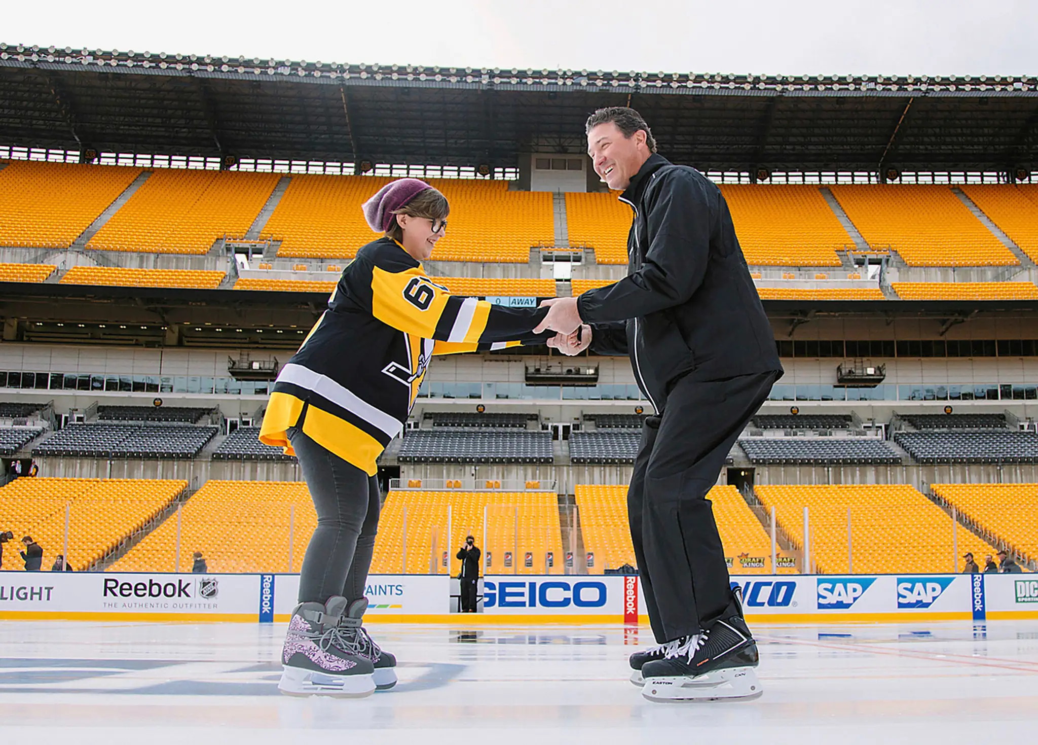 Legenda NHL Mario Lemieux (vpravo) korčuľuje s Lily Tarasiewicz, ktorá vyhrala boj s Hodkginovou chorobou.