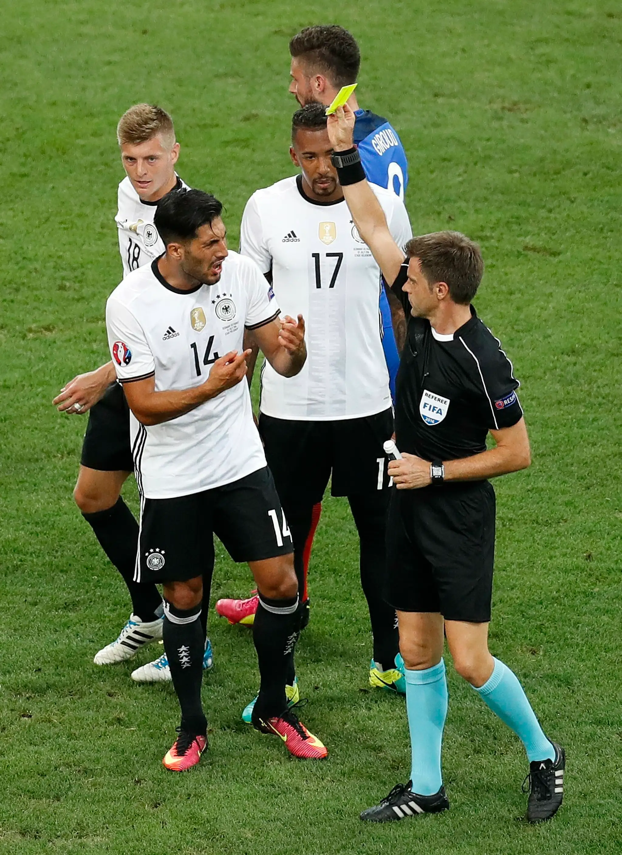 Rozhodca Nicola Rizzoli dáva žltú kartu Nemcovi Emre Canovi v semifinále ME proti Francúzsku.