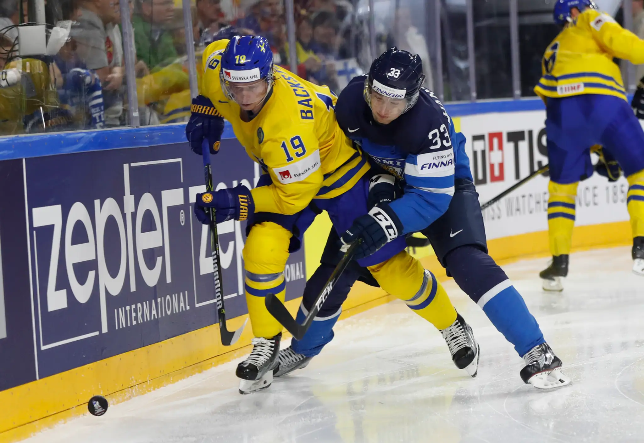 Nicklas Bäckström (vľavo) zo Švédska bojuje o puk s Fínom Markusom Hannikainenom v semifinále MS 2017.