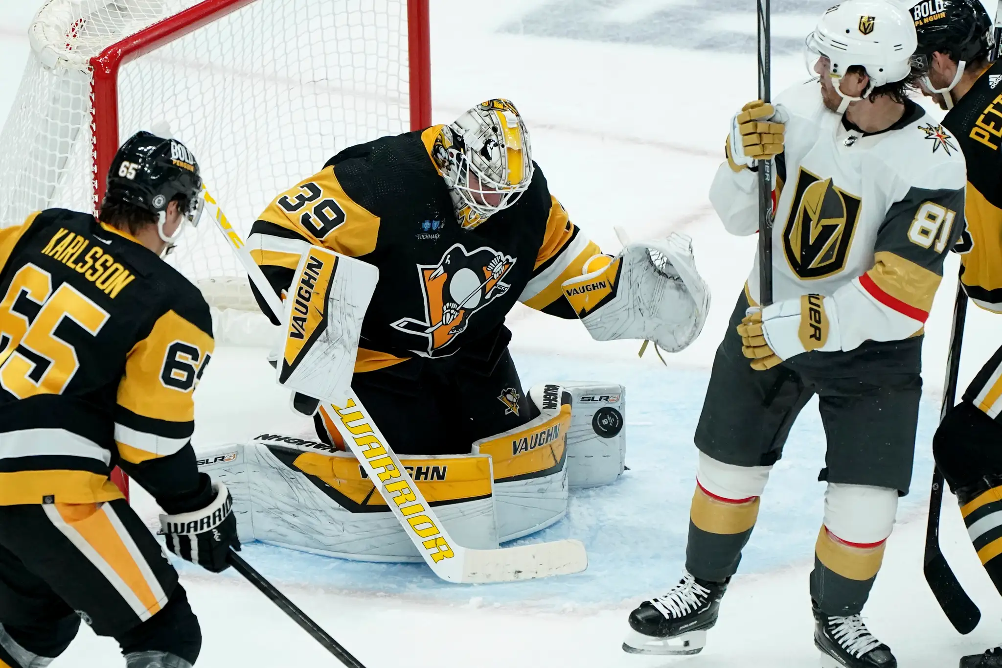 Na snímke druhý zľava brankár Penguins Alex Nedeljkovic chytá puk.