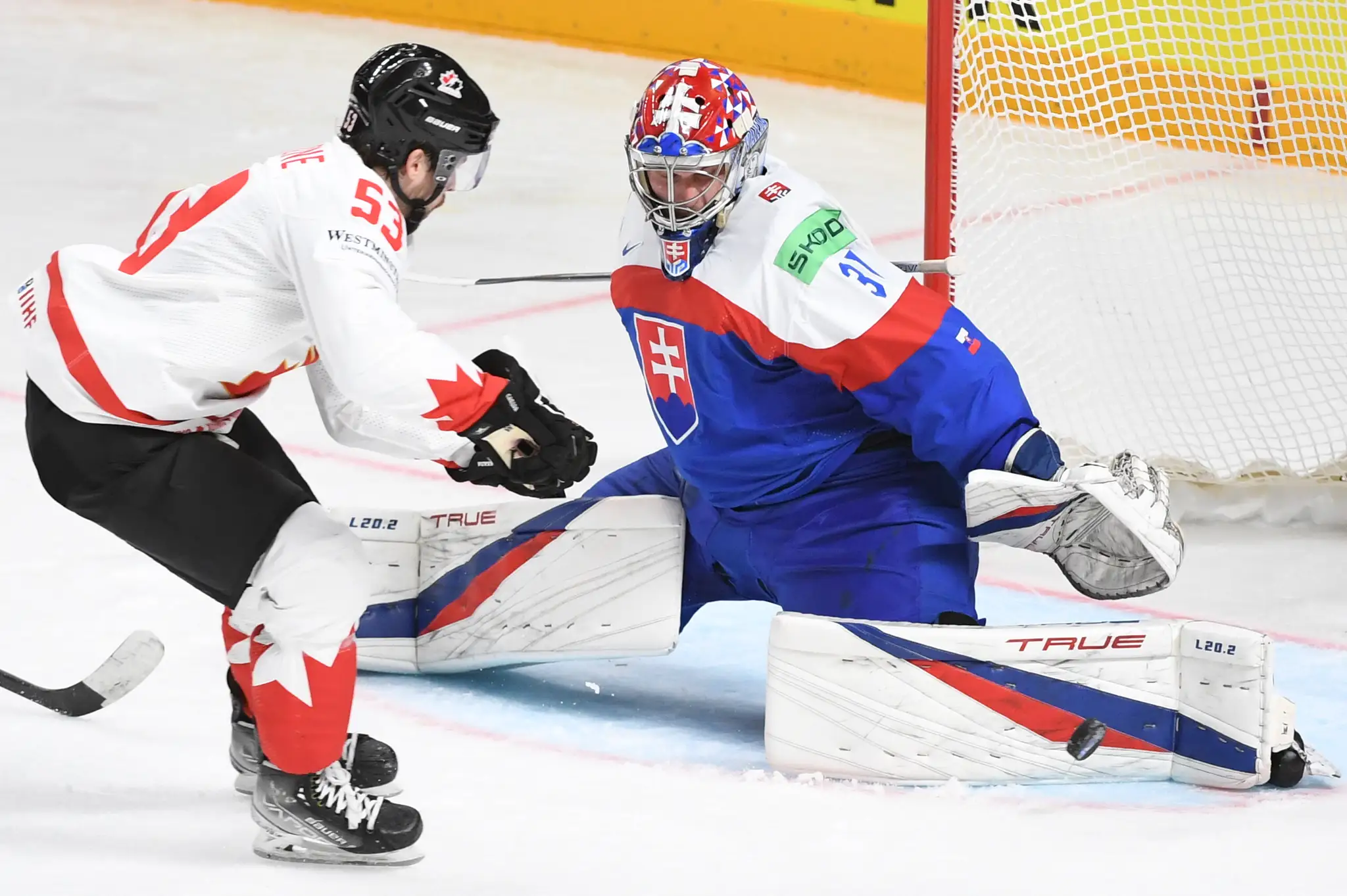 Na snímke vpravo brankár Slovenska Samuel Hlavaj a vľavo útočník Kanady Michael Carcone.