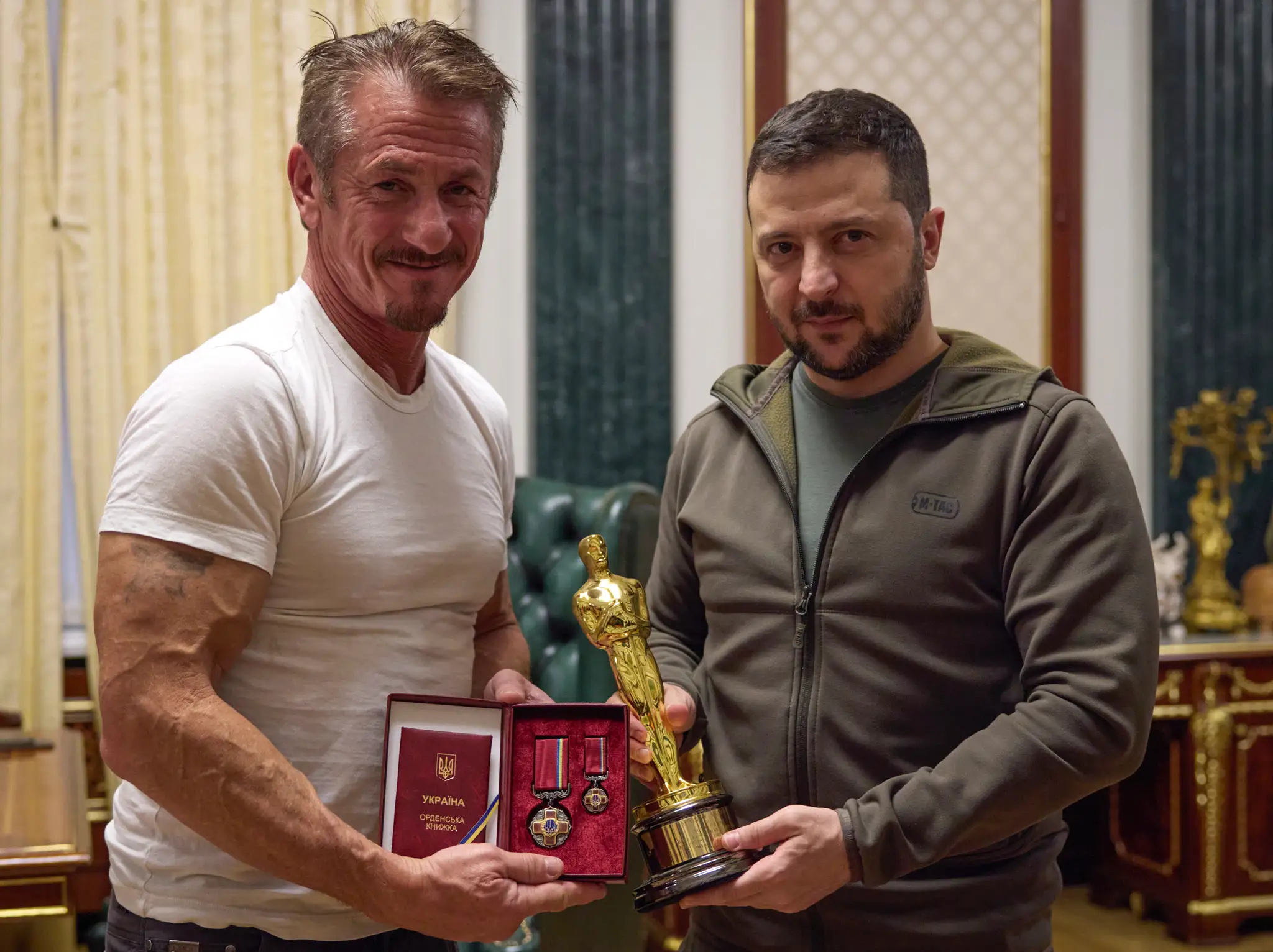 Ukrajinský prezident Volodymyr Zelenskyj (vľavo) a americký herec Sean Penn pózujú so soškou Oscara a ukrajinským vysokým štátnym vyznamenaním.