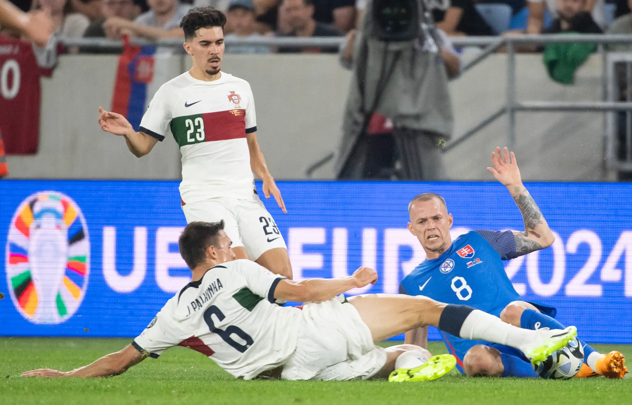 Na snímke sprava hráč Slovenska Ondrej Duda a hráči Portugalska Joao Palhinka a Vitihna .