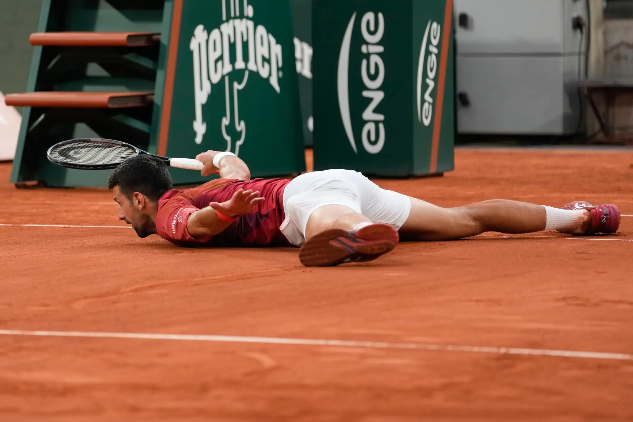 Na snímke srbský tenista Novak Djokovič leží na dvorci.