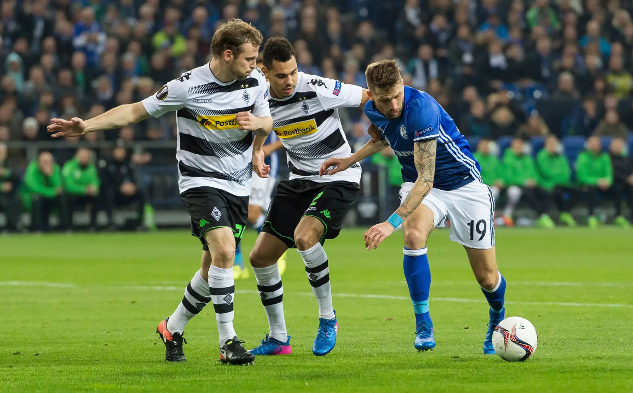 Guido Burgstaller (vpravo) zo Schalke v obkľúčení dvojice z Mönchengladbachu Timothéem Kolodziejczakom (v strede) a Tony Jantsch