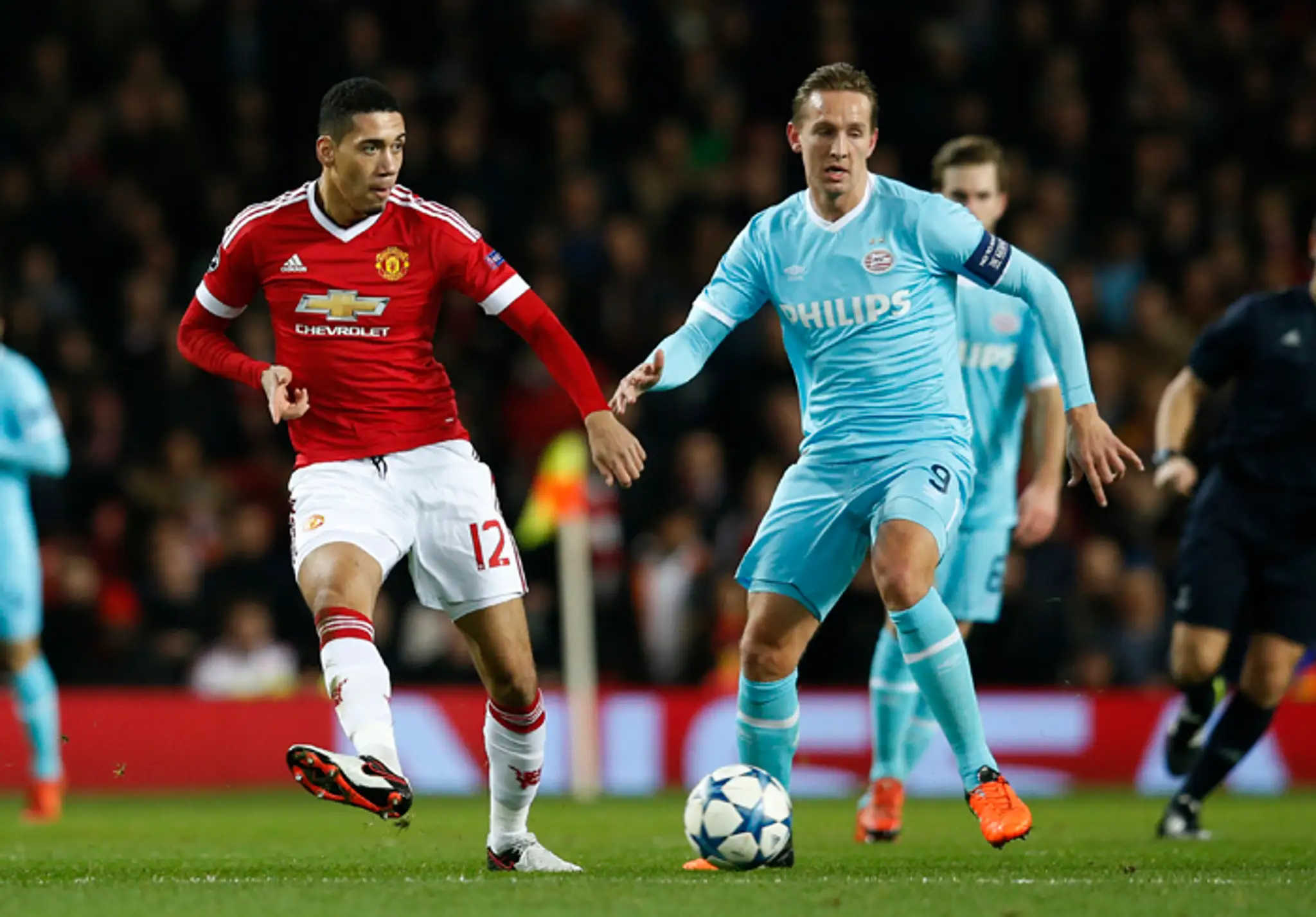vľavo hráč Manchester United Chris Smalling, vpravo hráč PSV Luuk de Jong v zápase LM.