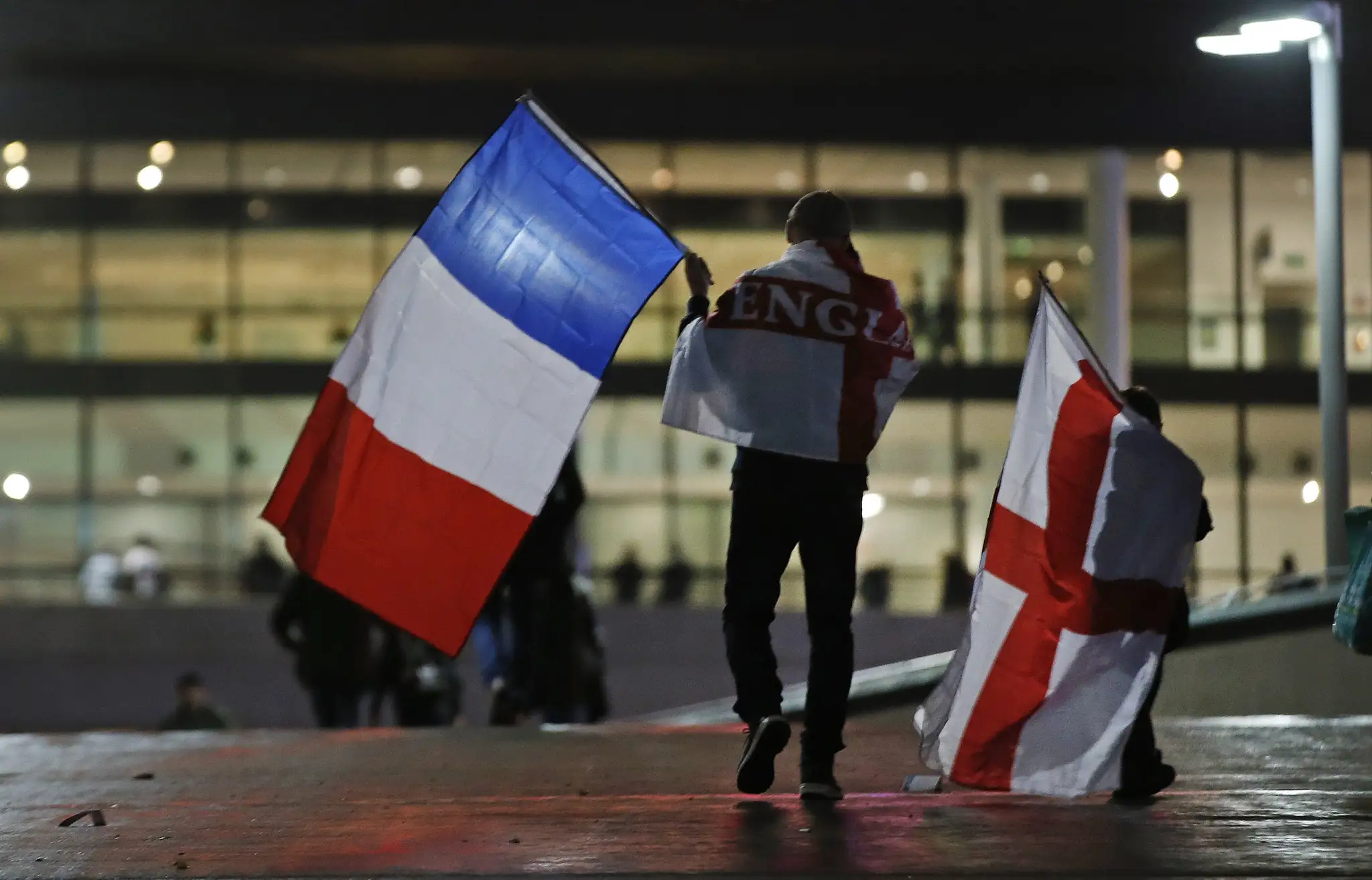 Fanúšik kráča na štadión Wembley s oboma zástavami 