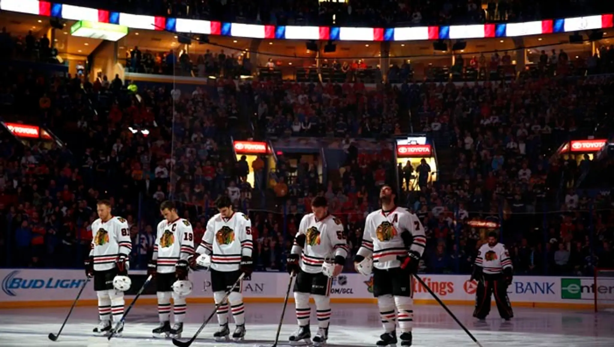 Hráč Chicaga Blackhawks Marián Hossa (vľavo) so spoluhráčmi si uctili obete piatkových teroristických útokov v Paríži pred zápas