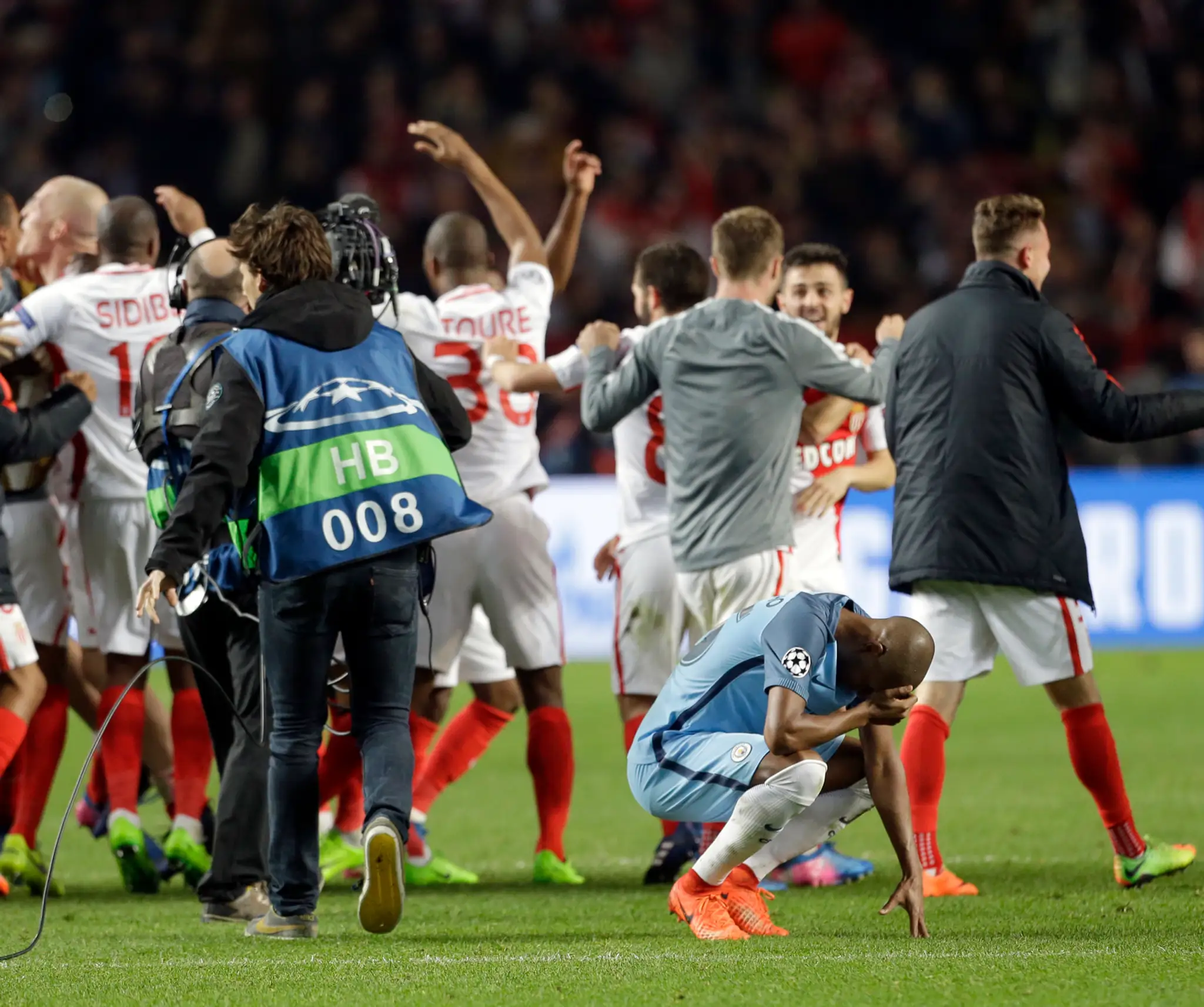 Smútok Fernandinha z ManCity po vypadnutí v osemfinále LM, v pozadí radosť z postupu v podaní hráčov Monaca.