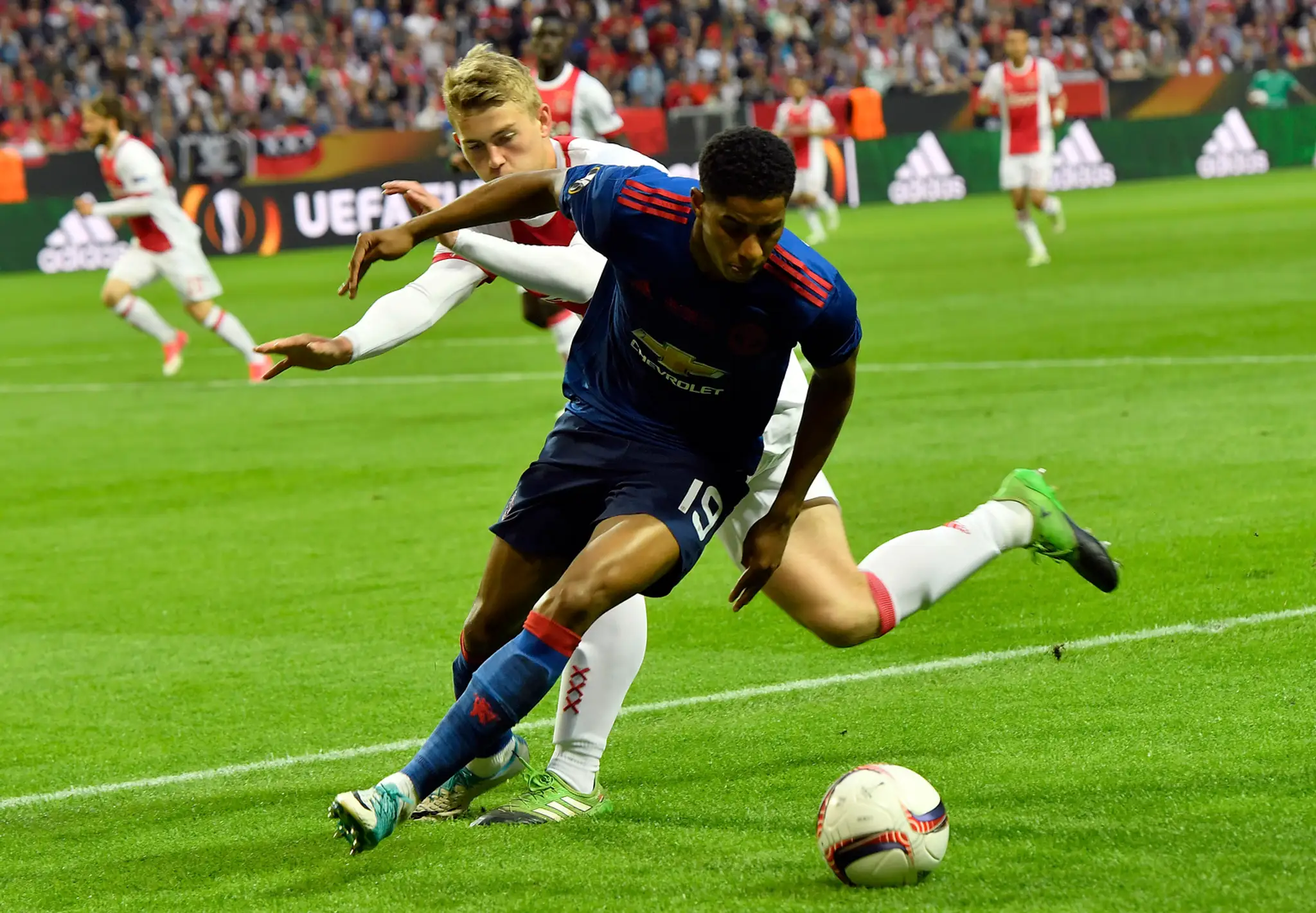 Matthijs de Ligt (v pozadí) atakuje vo finále EL Marcusa Rashforda z ManUtd.