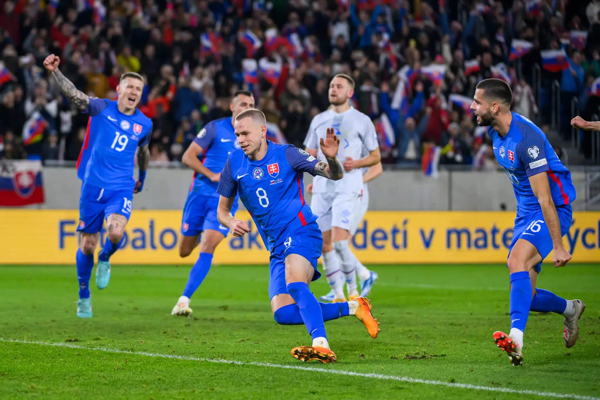 Gólová radosť hráčov Slovenska, uprostred Ondrej Duda v zápase kvalifikácie ME 2024 proti Islandu.