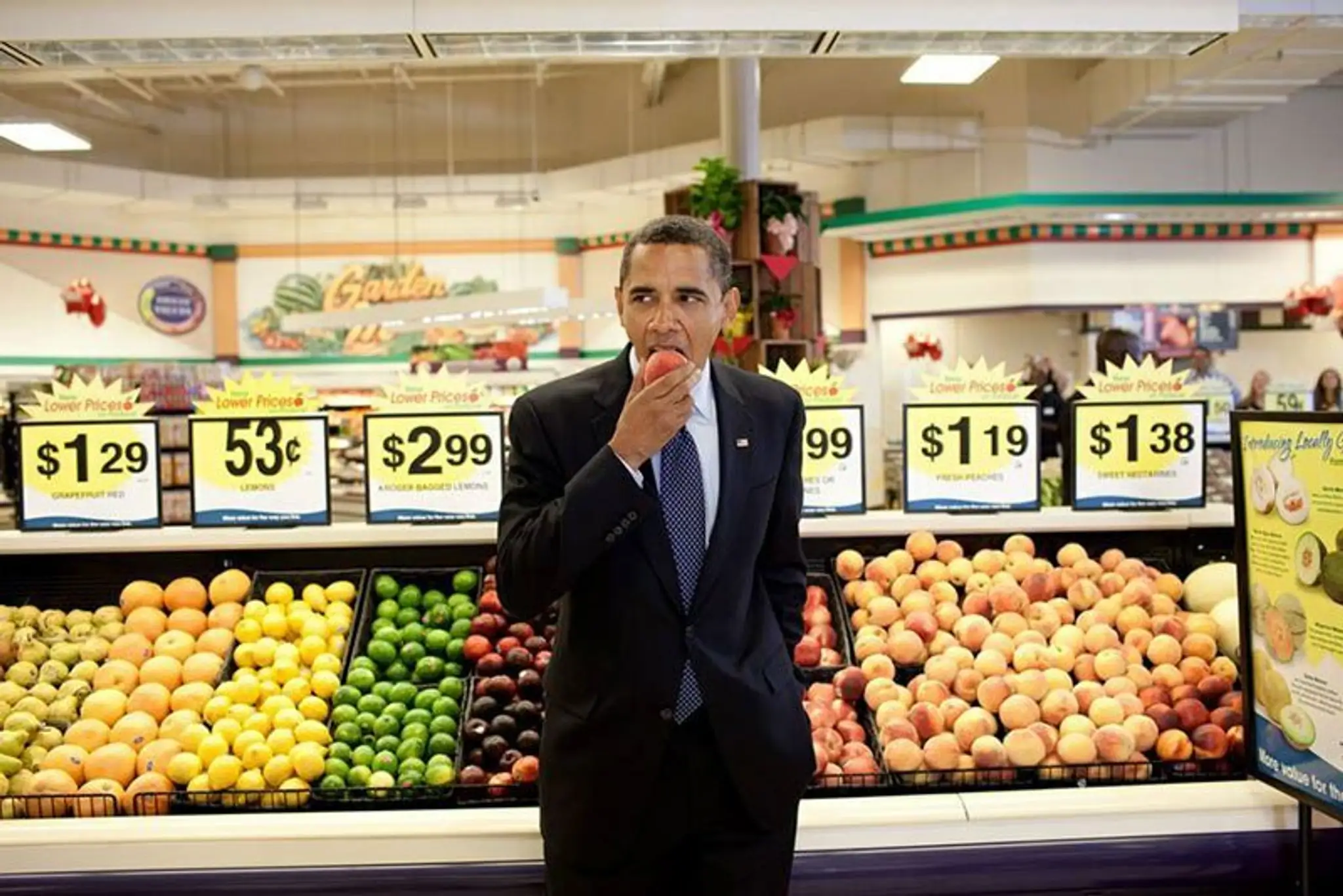 Prezident Obama skúša jablko v supermarkete.
