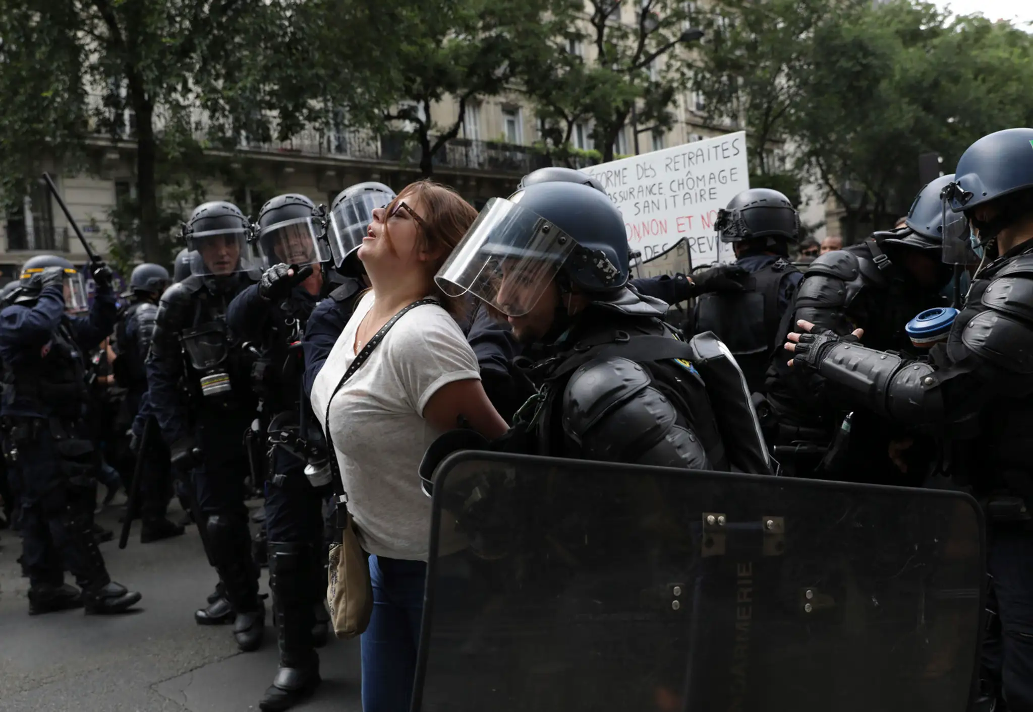 Polícia zadŕža demonštrantku v Paríži.