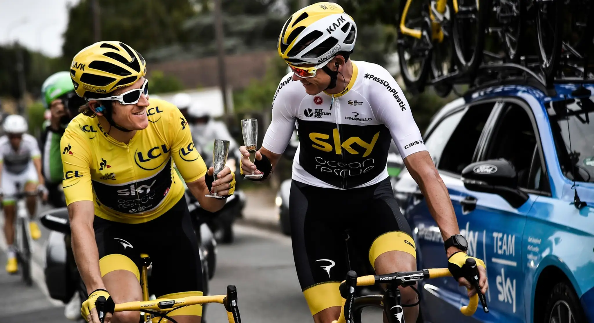 Geraint Thomas  v žltom drese a jeho tímový kolega Christopher Froome si pripíjajú so šampanským počas 21. etapy TdF 2018.