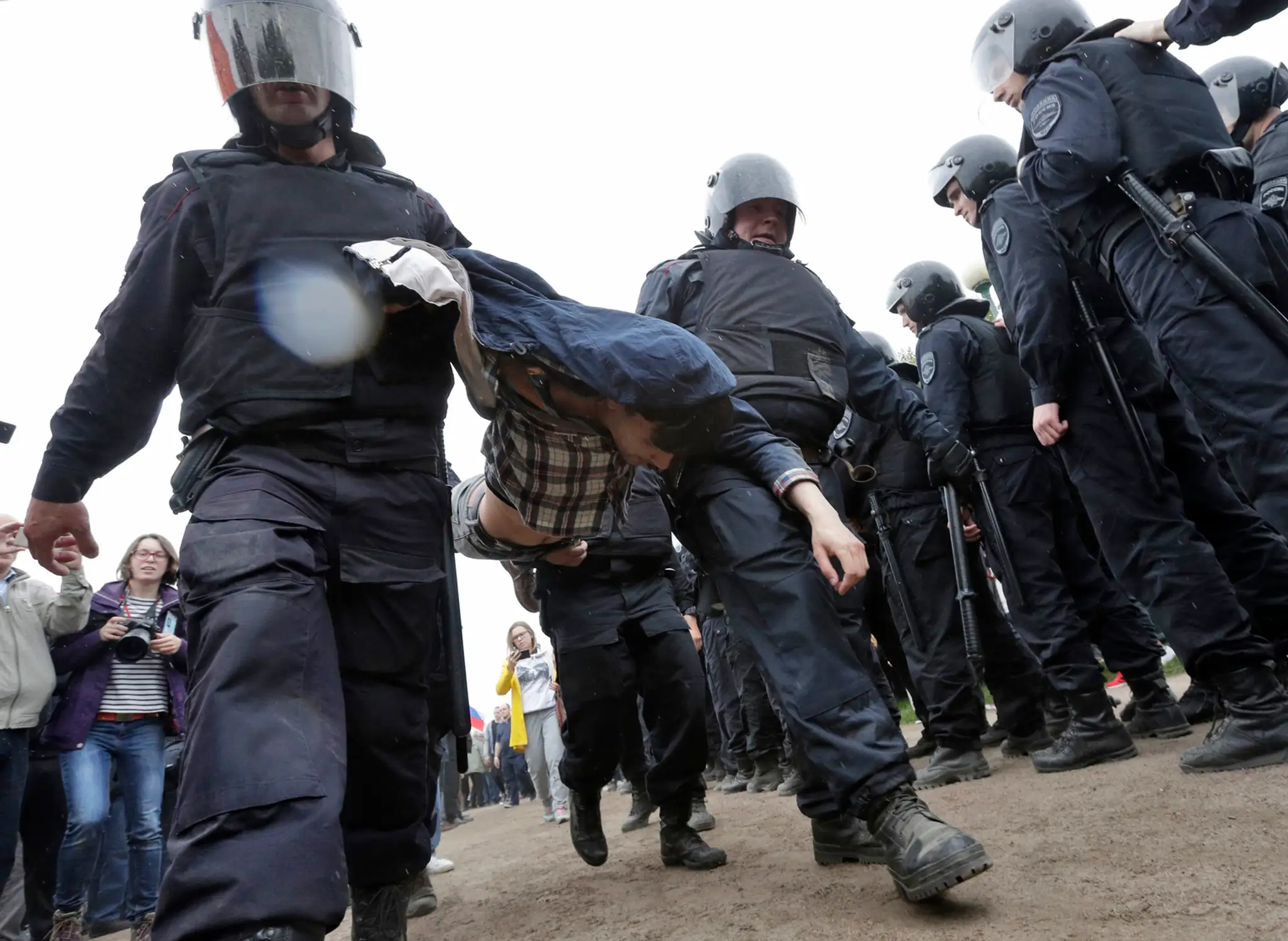 Ruská polícia odnáša demonštranta.