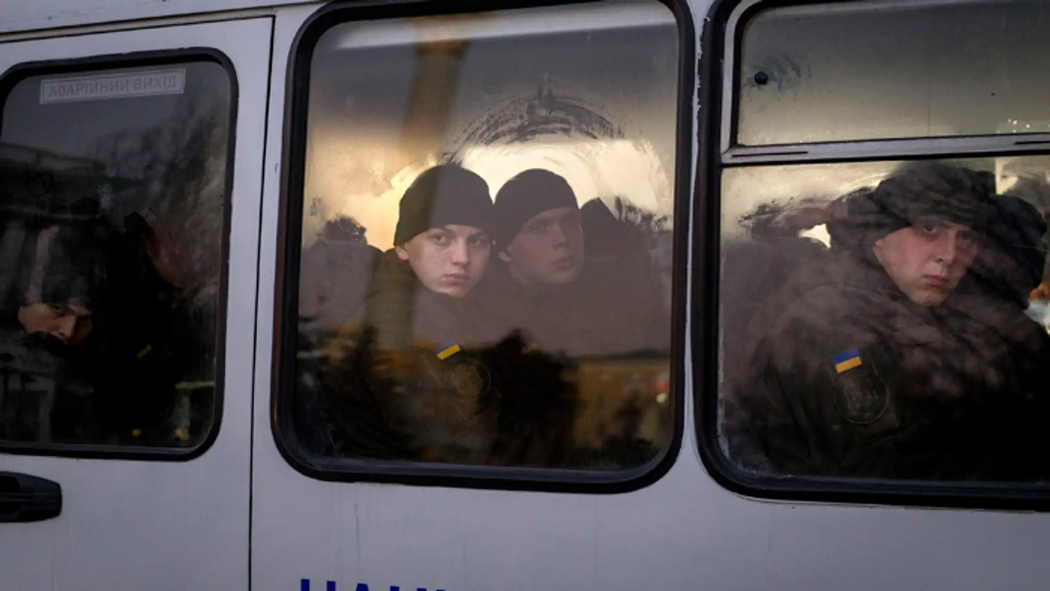 Príslušníci Národnej gardy Ukrajiny sa pozerajú z okna autobusu pri jazde v centre Kyjeva.