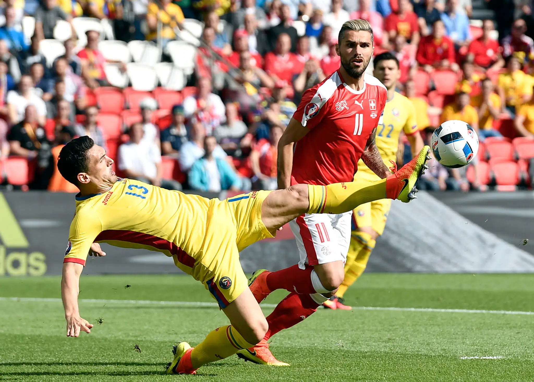 Rumun Claudiu Keseru (vľavo) a Valon Behrami zo Švajčiarska v súboji počas duelu na ME vo Francúzsku.