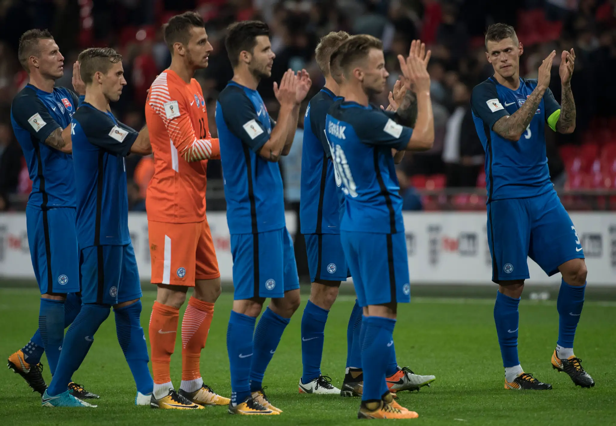 Smutní slovenskí futbalisti ďakujú divákom po prehre v kvalifkácii v Anglicku.