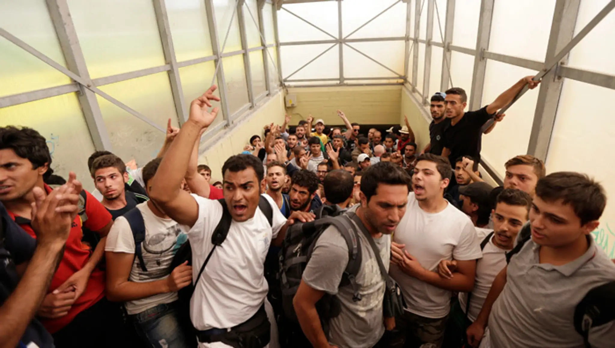 Na snímke migranti skandujú "No camp!" (Nie tábor) na železničnej stanici v maďarskom meste Bicske.