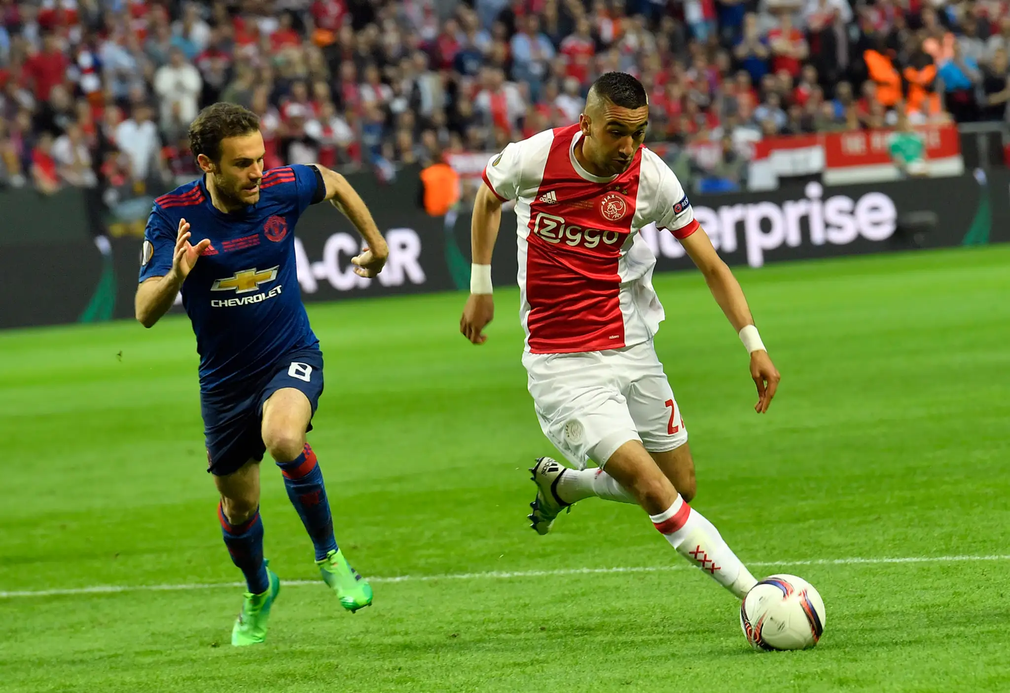 Hakim Ziyech (vpravo) z Ajaxu uniká vo finále EL Juanovi Matovi z ManUtd.