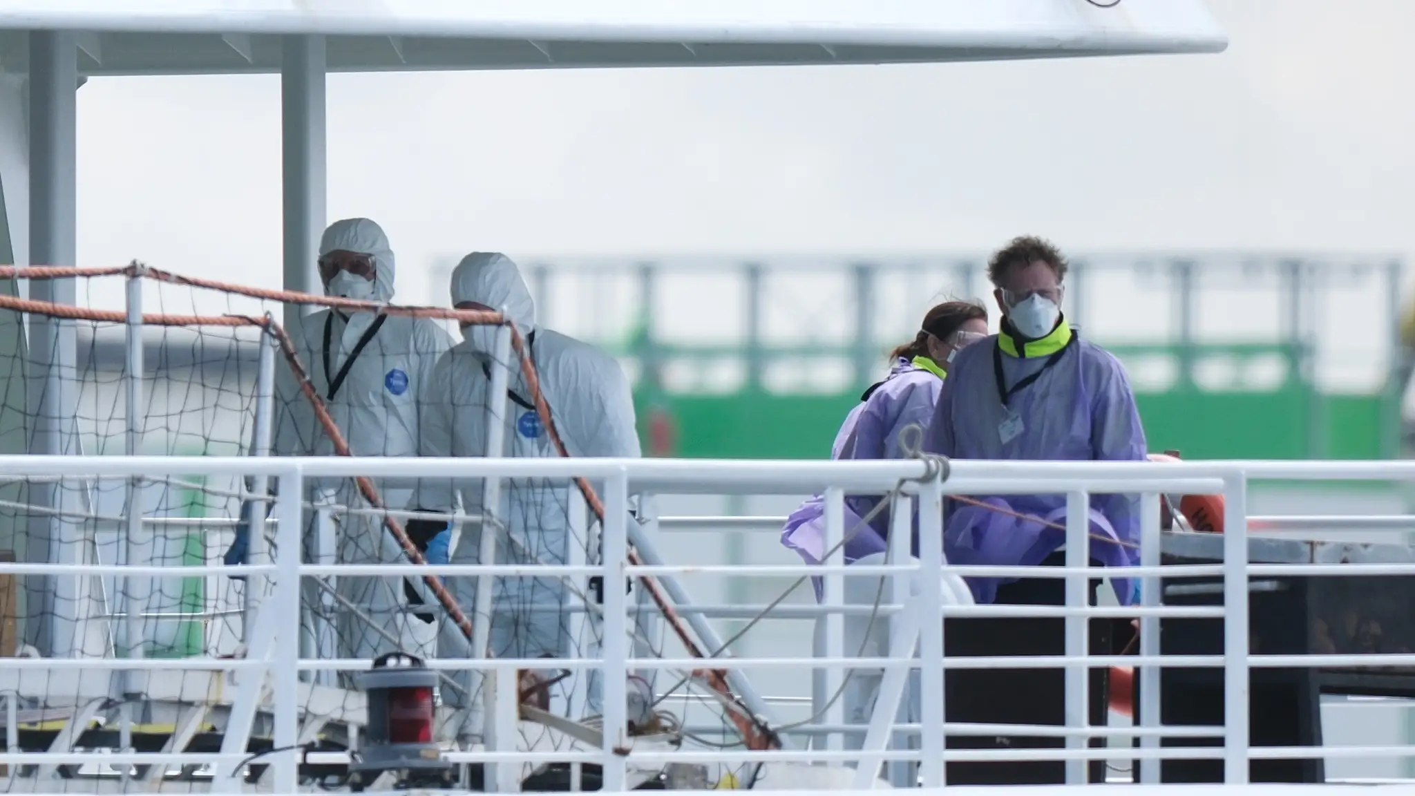 Posádka v ochranných pomôckach na výletnej lodi MV Hondius po jej príchode do rotterdamského prístavu.