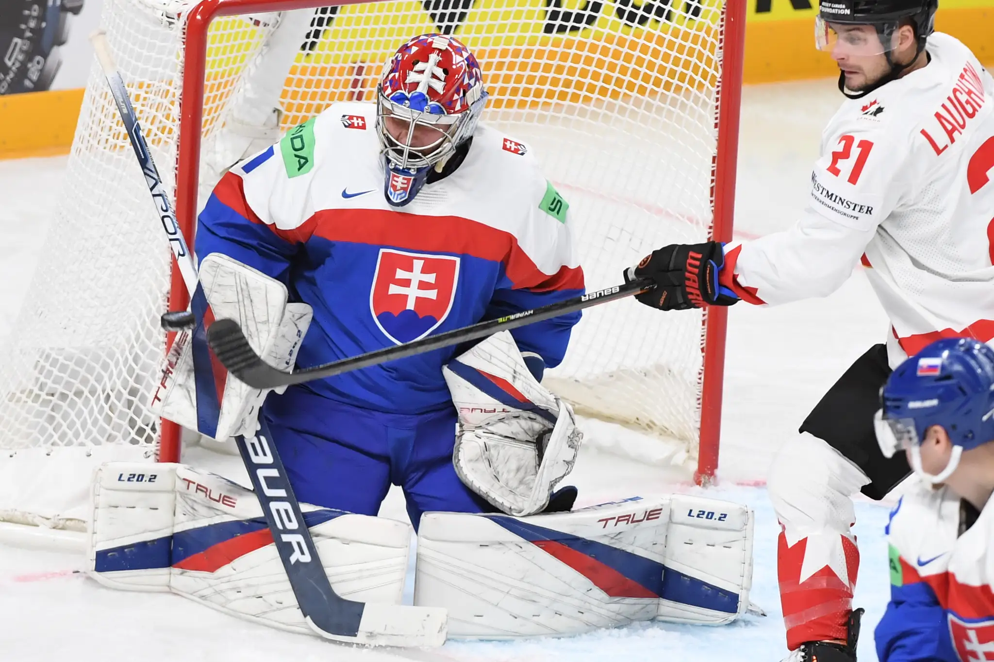 Na snímke vľavo brankár Slovenska Samuel Hlavaj, vpravo center Kanady Scott Laughton .